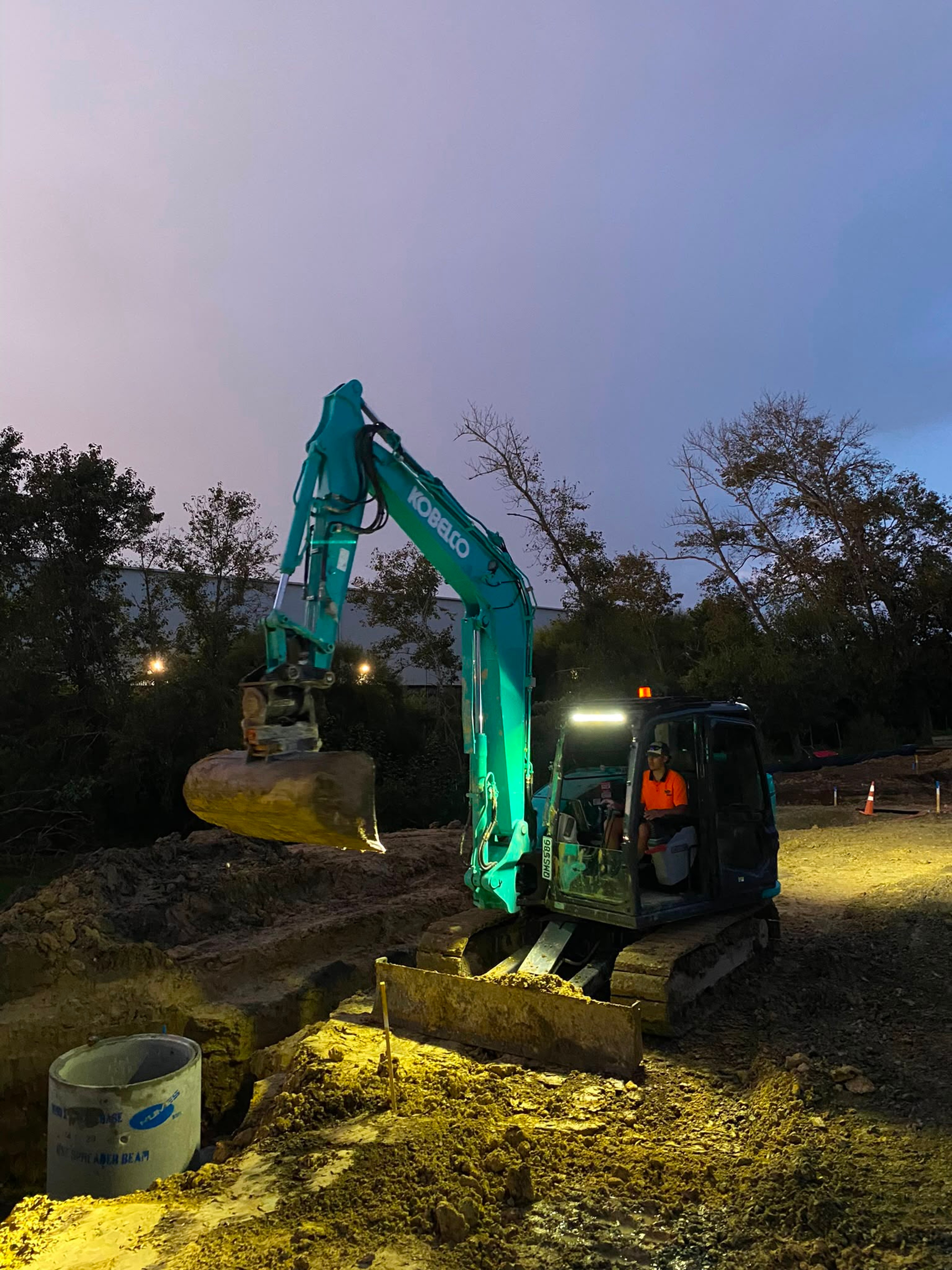 Excavator working on site at dusk