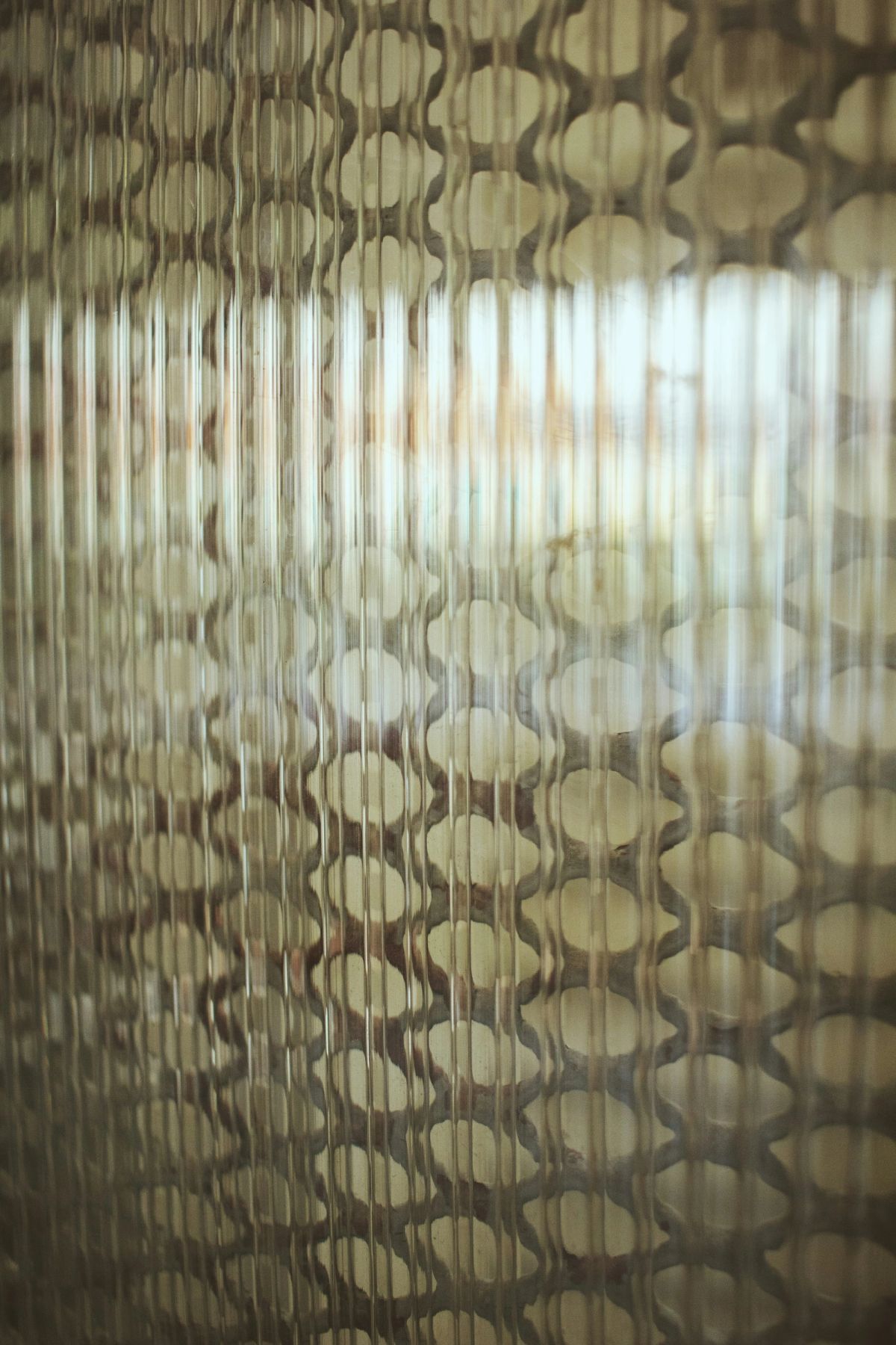 Warm light broken into ovals behind a sheet of ribbed glass
