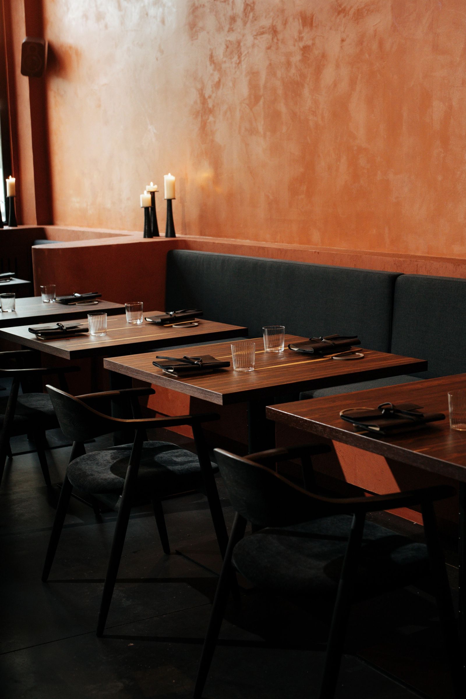 De eetzaal met gedekte tafels en warme terracotta muren