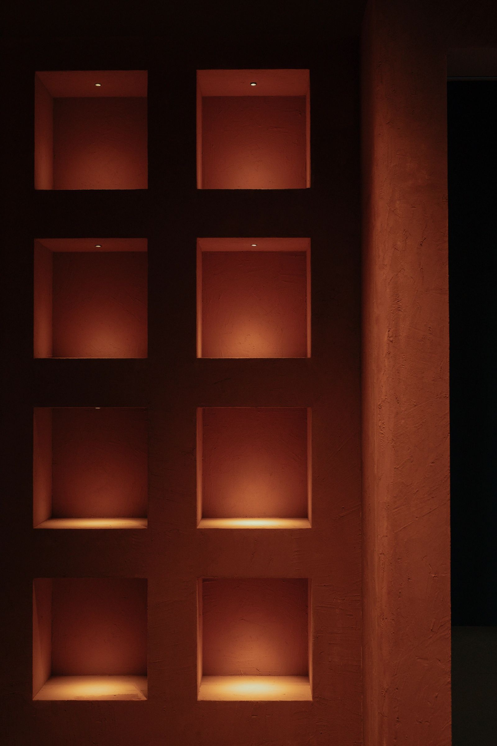Verlichte nissen in een terracotta muur