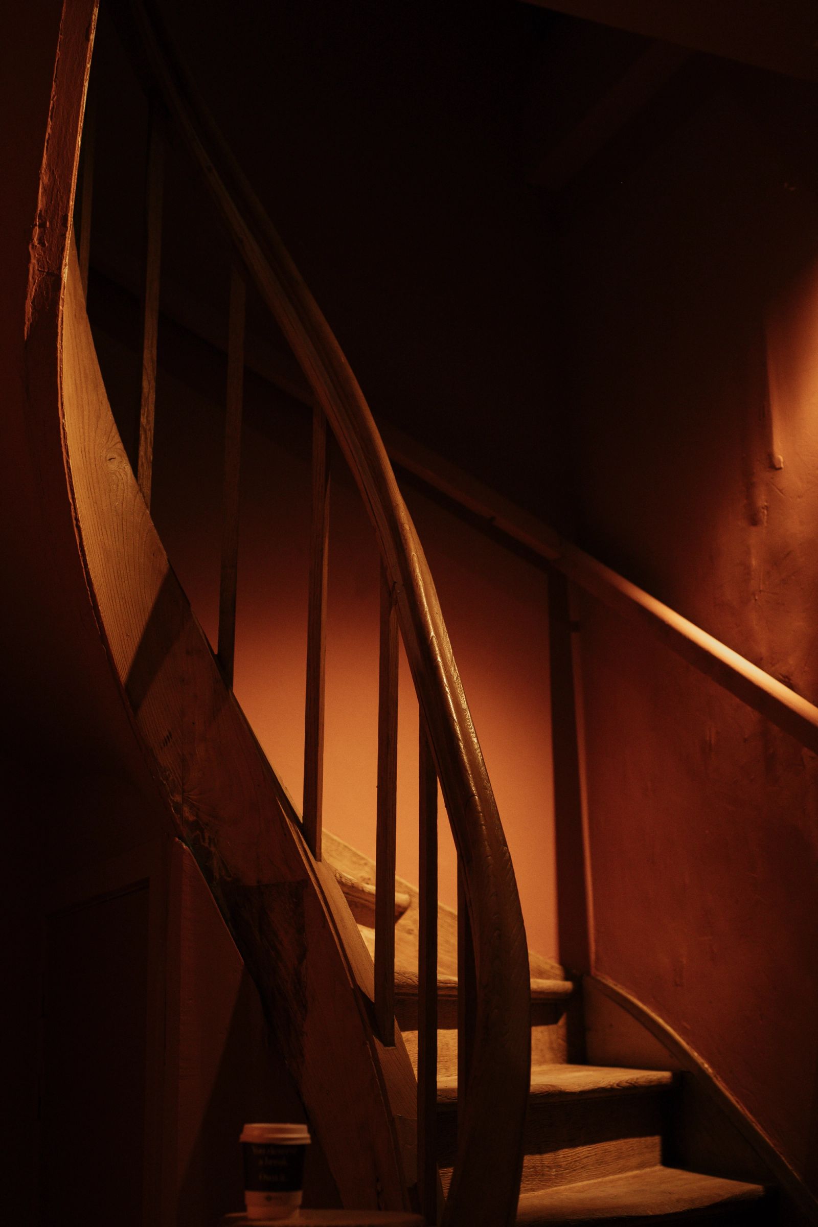 Een houten wenteltrap in warm licht
