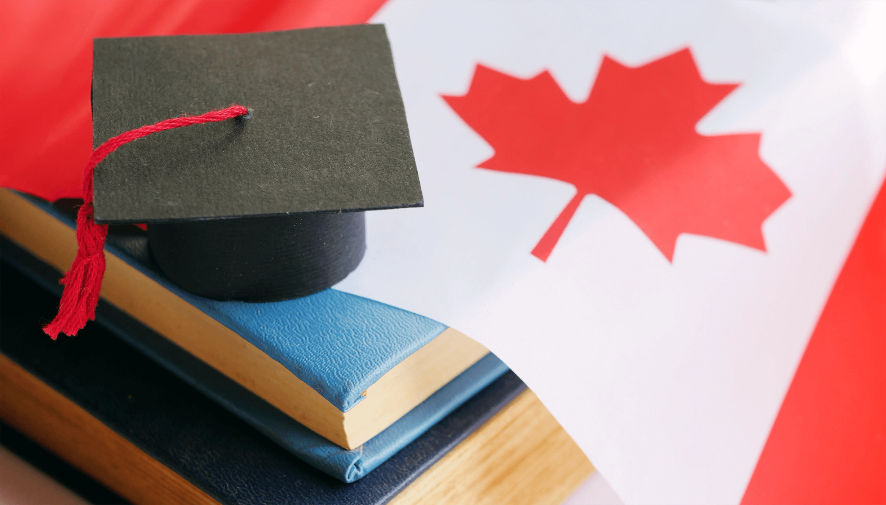 A Canadian flag with a grad cap on top of it.