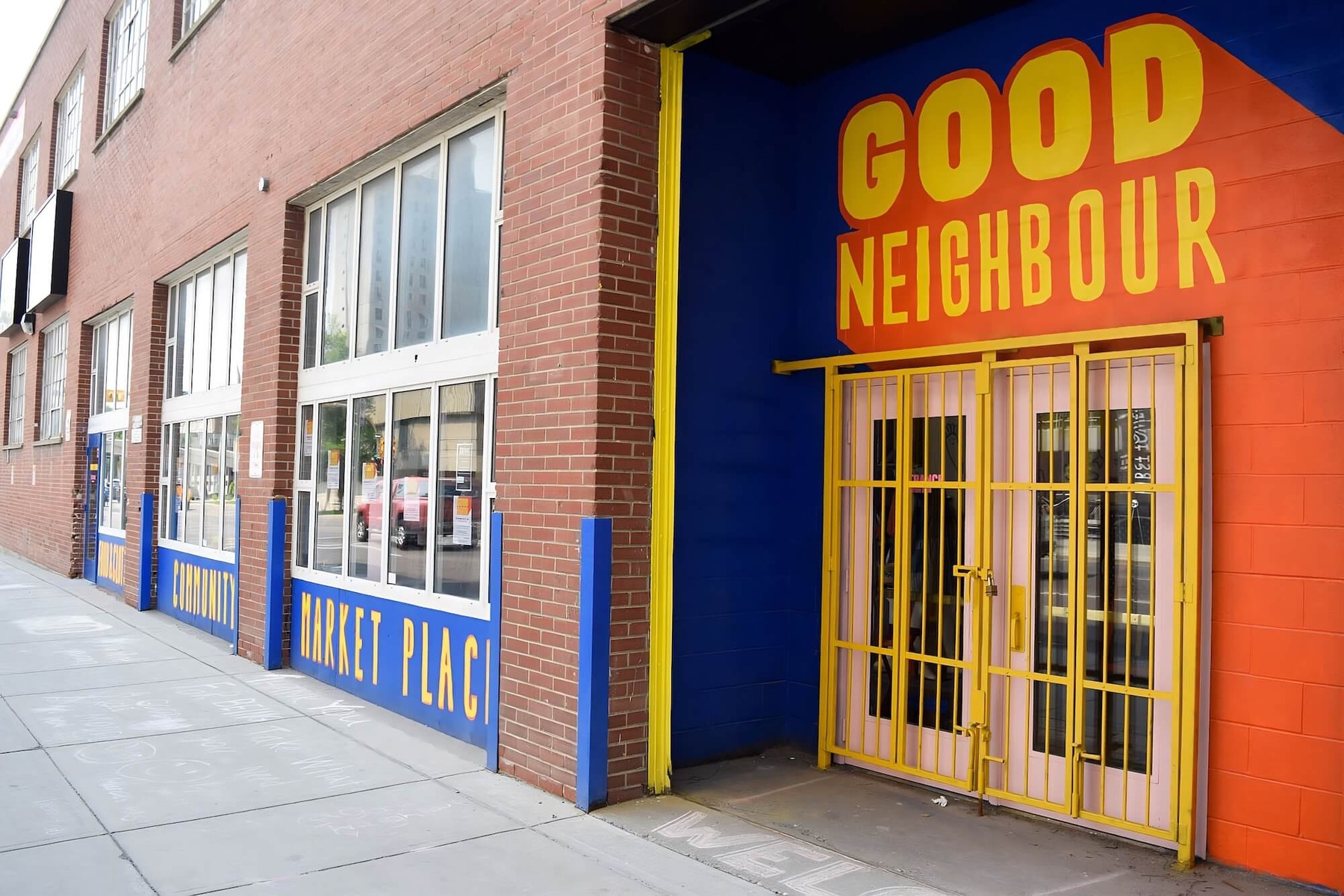 A community marketplace with an orange sign reading 'Good Neighbour'