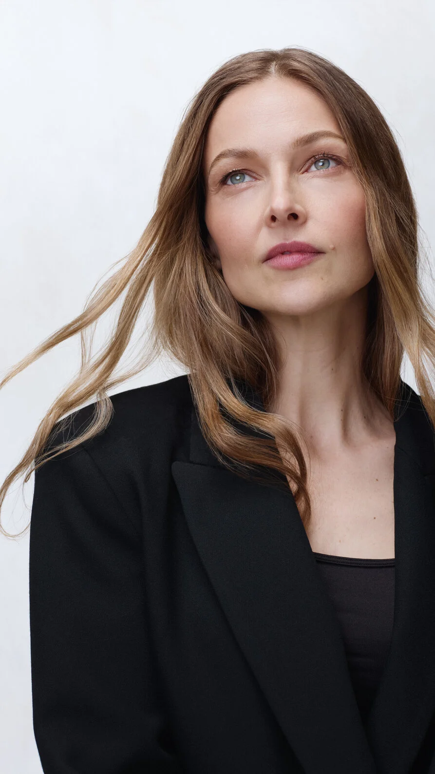 Portrait of a woman with chin lifted and gaze upward — representing the precision and results of ultrasound and RF skin tightening treatments.