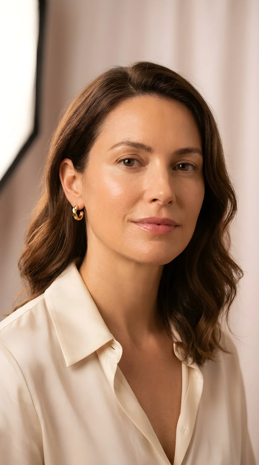 Close portrait of a woman with natural skin texture and a composed expression — representing subtle, natural aesthetic outcomes.