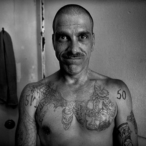 Eddie Tate showing some of his prison tattoos in the Old San Bruno County Jail, south of San Francisco, August 4, 2006 (Photo by Robert Gumpert via Harper's Magazine).