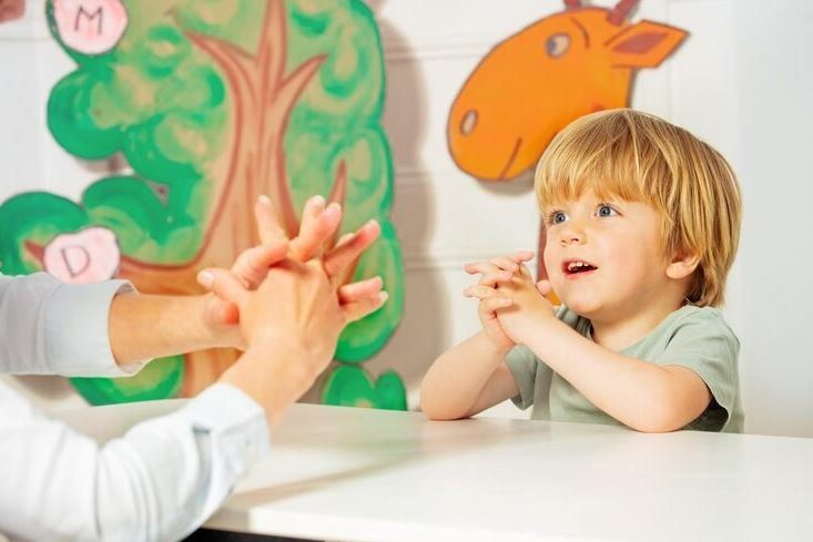 Niño trabajando con una profesional en una sala infantil