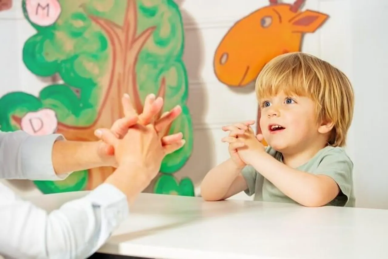 Niño trabajando con una profesional en una sala infantil