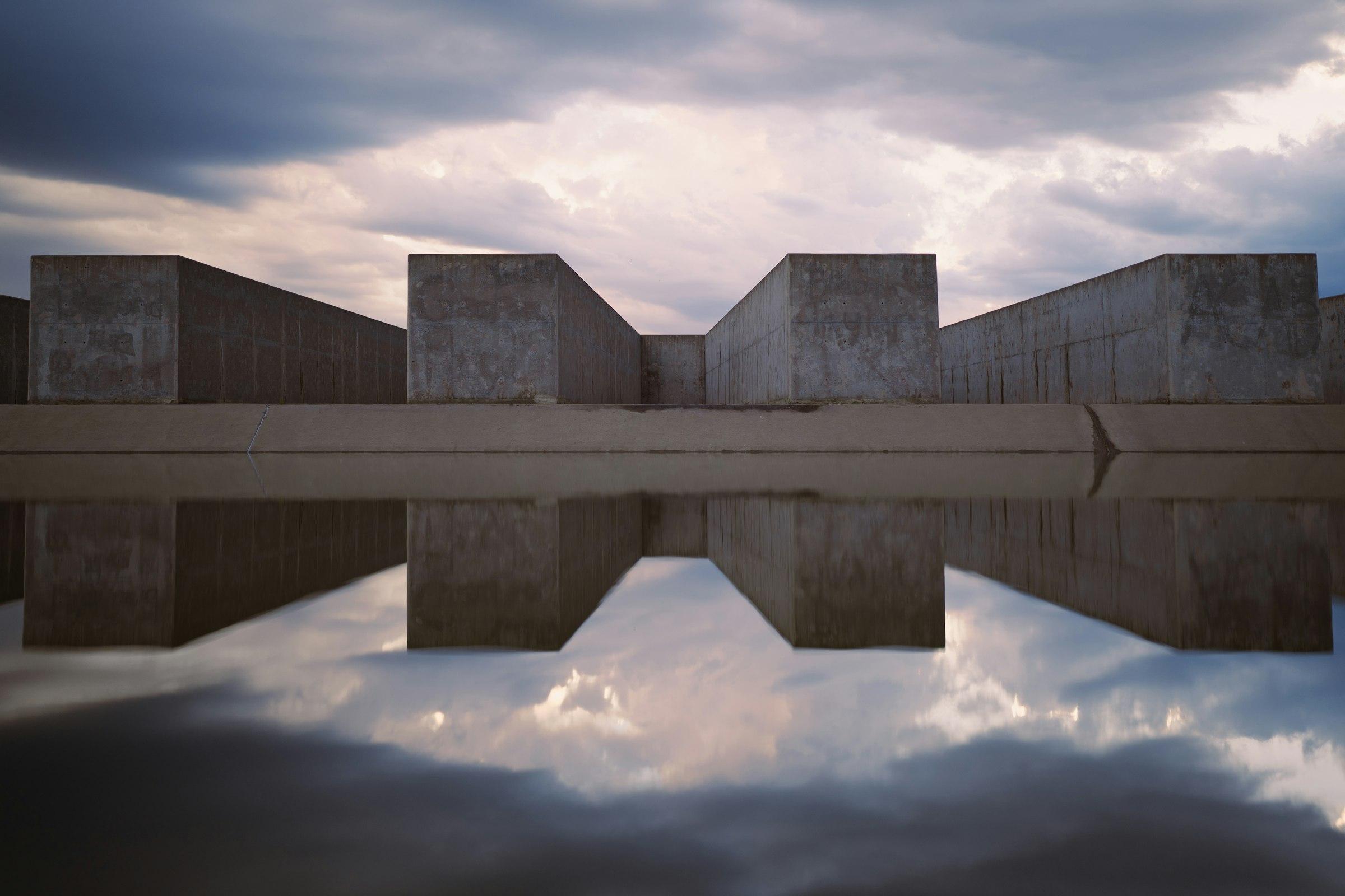 A building reflected in a still body of water