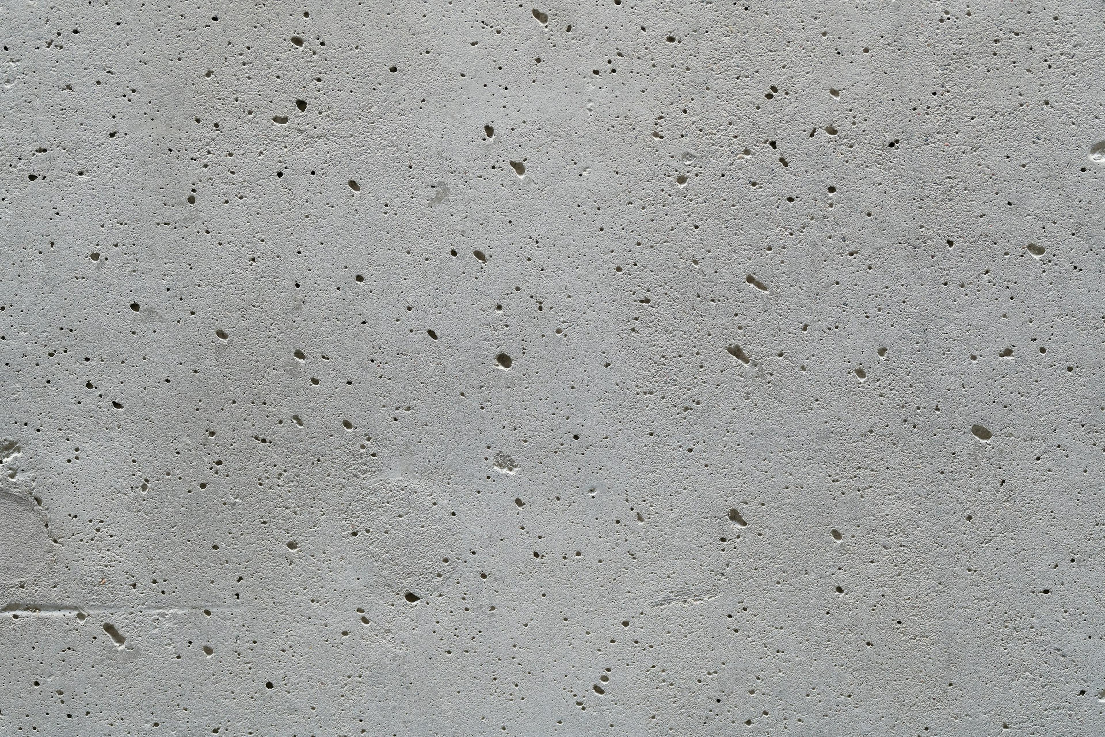A cast concrete wall with a grid of small openings