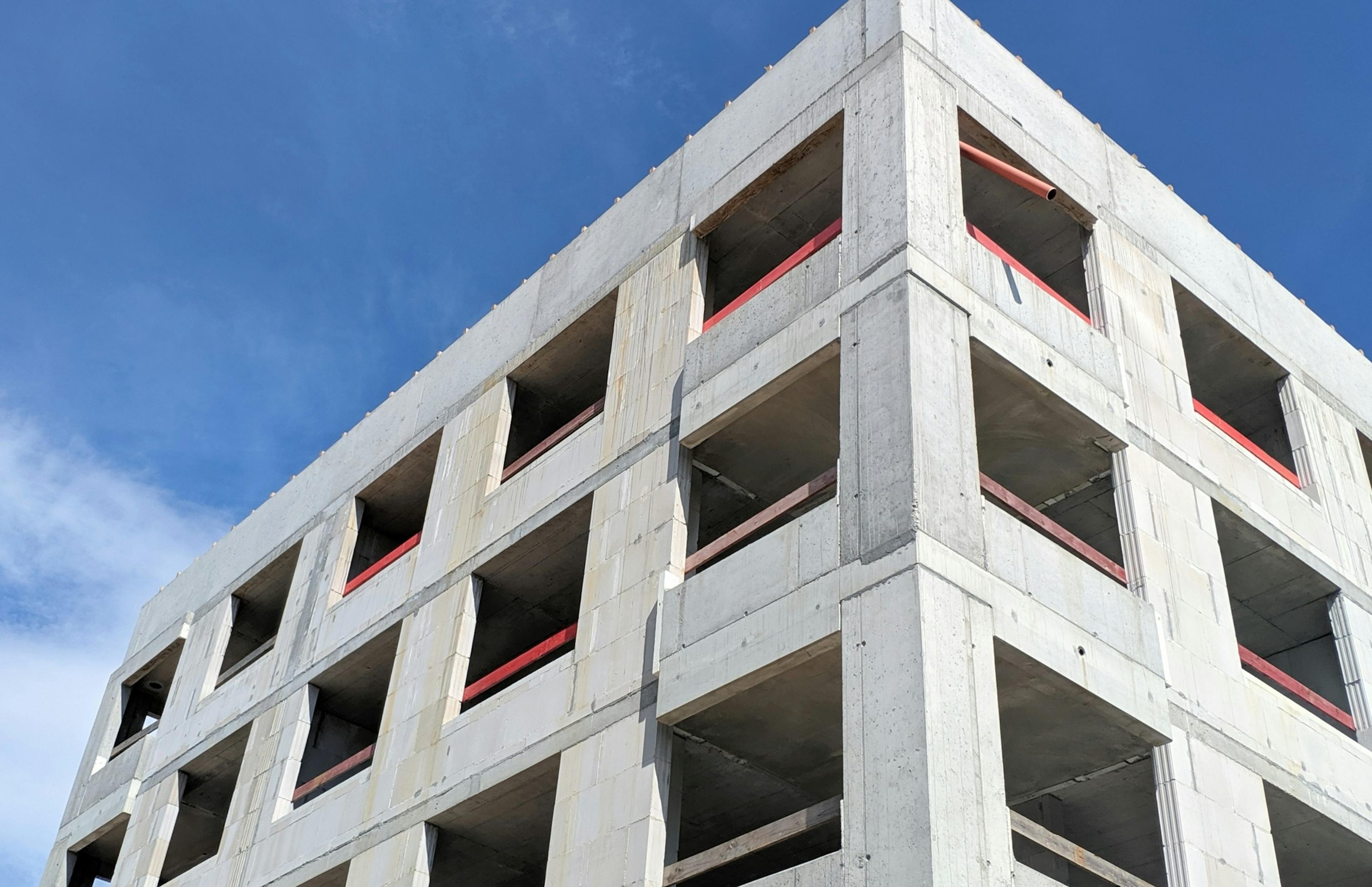 A tall concrete building under a blue sky