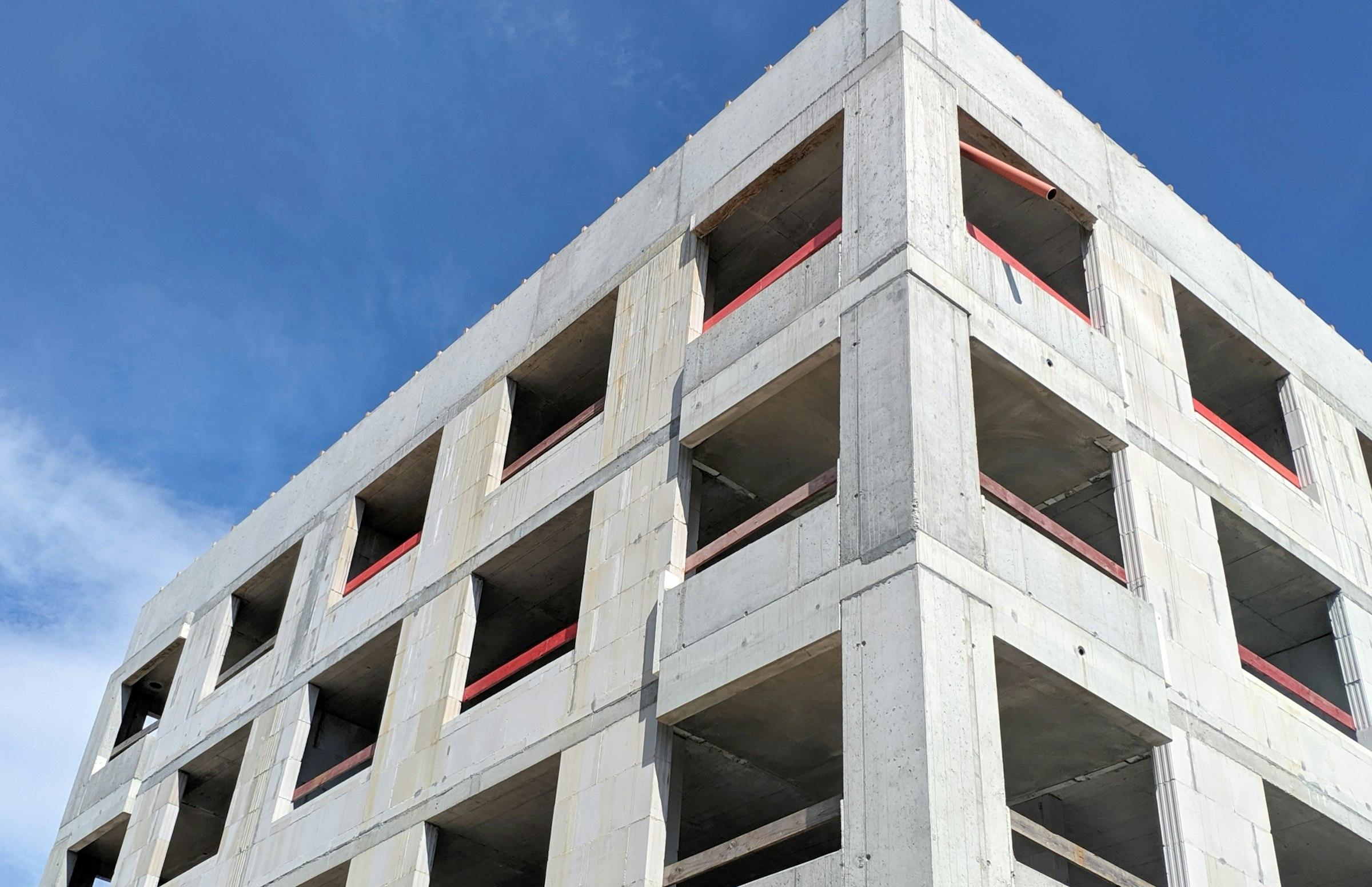 A tall concrete building under a blue sky