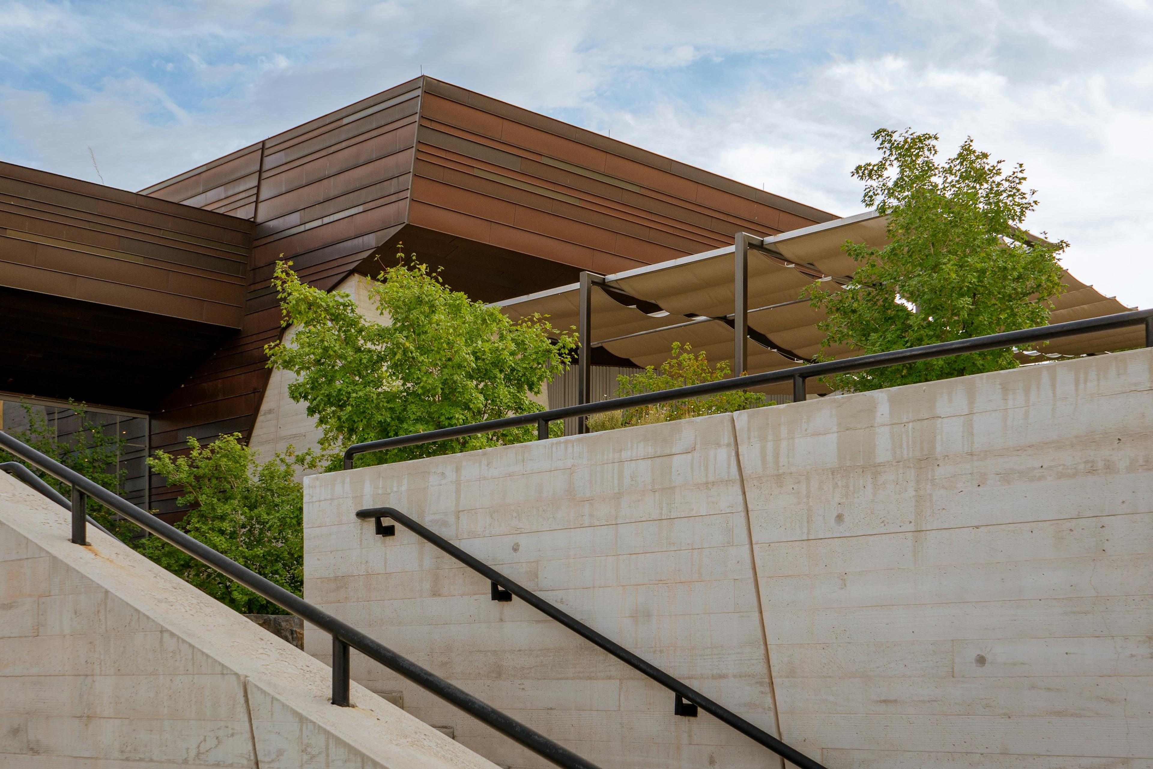 A building edge with a railing and trees beyond