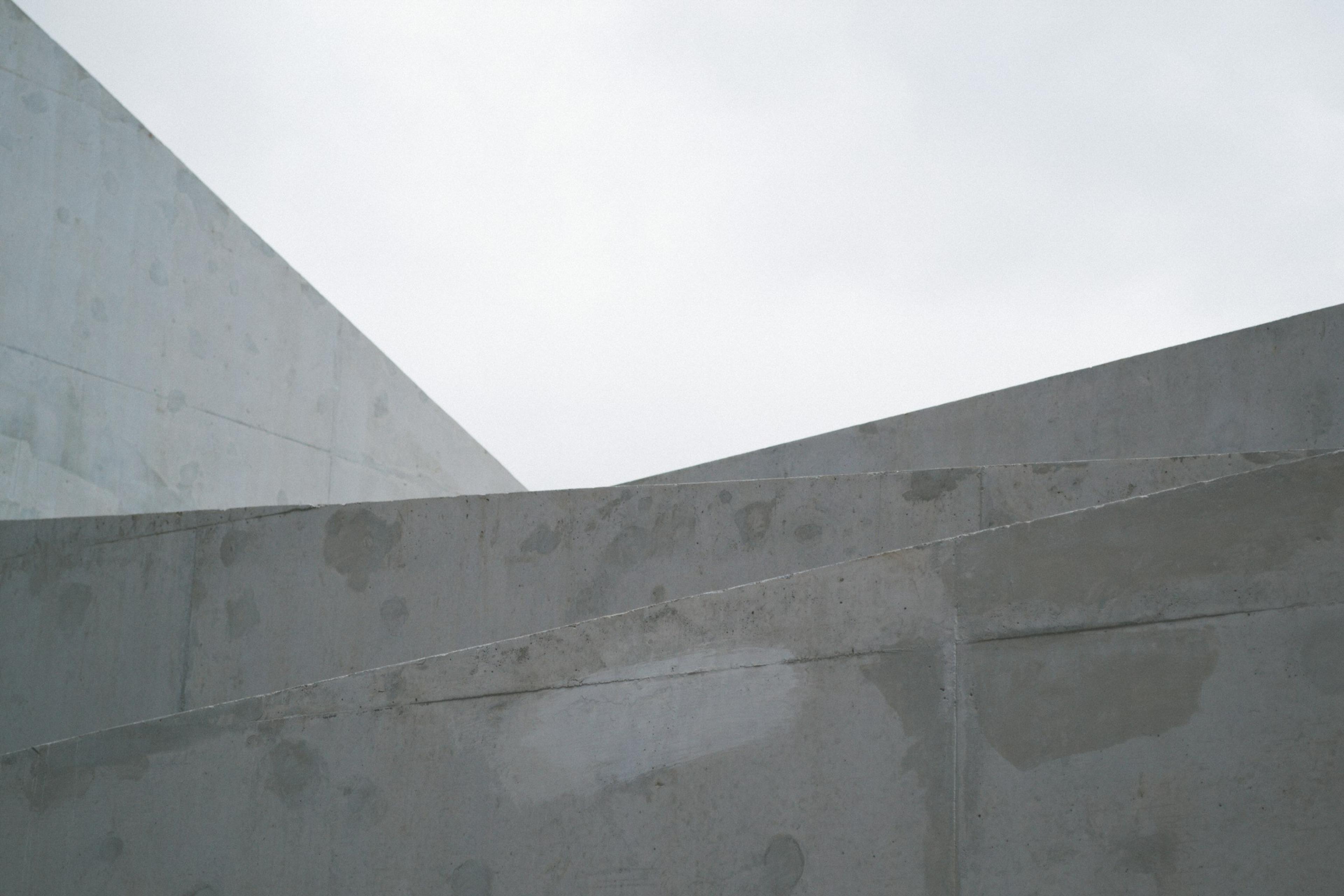 Abstract geometric building forms against a cloudy sky
