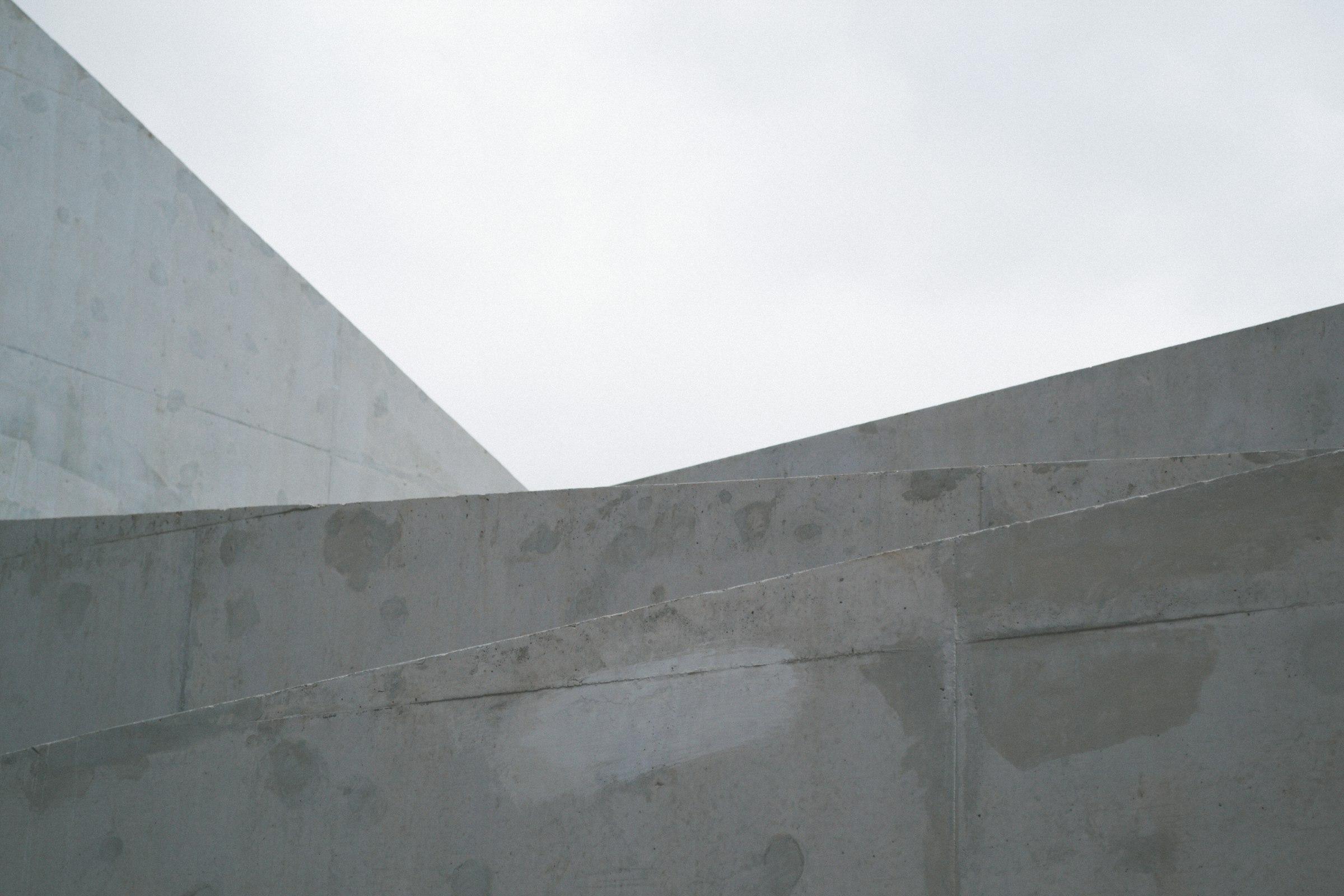 Abstract geometric building forms against a cloudy sky