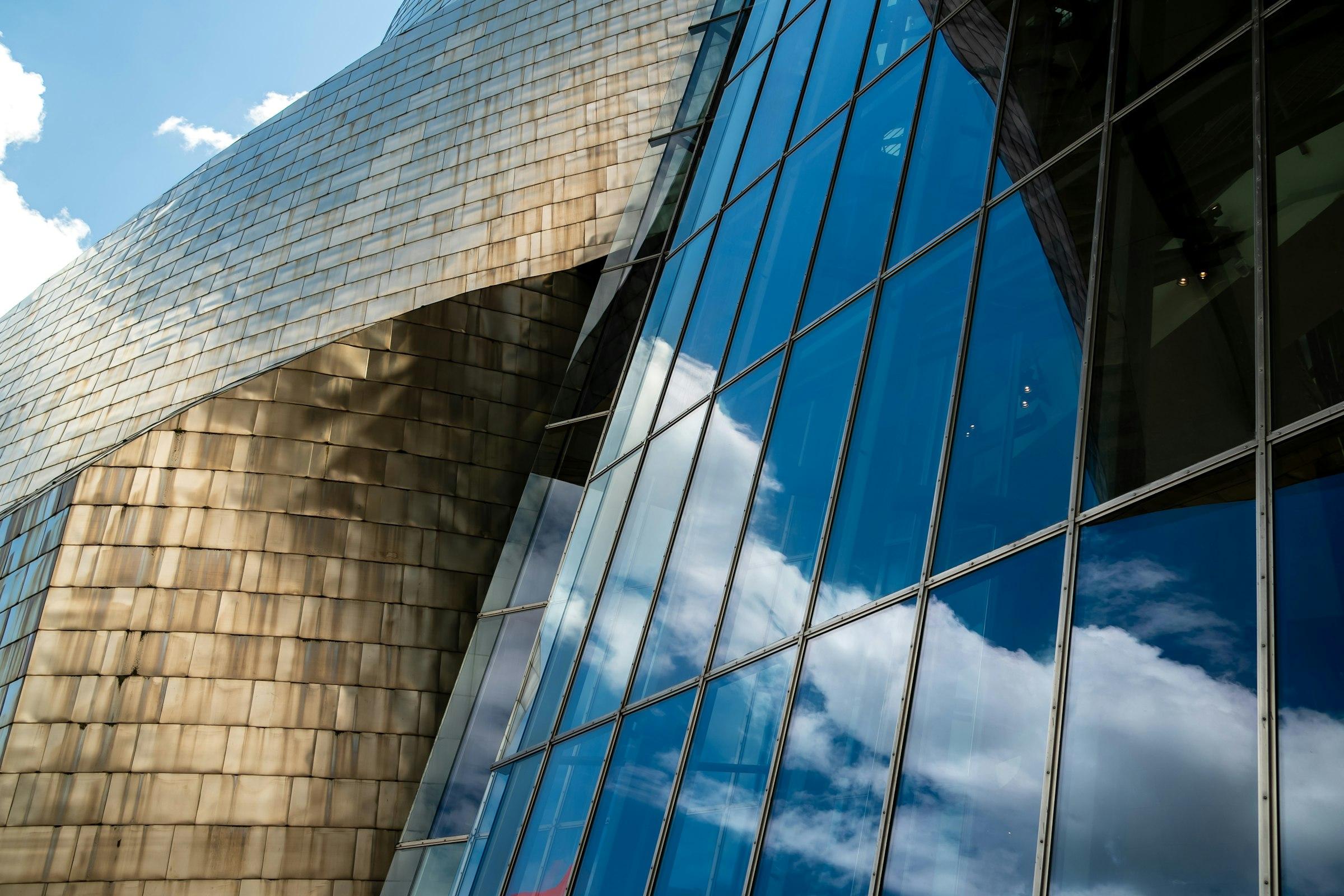 Modern building with a metallic facade reflecting a blue sky