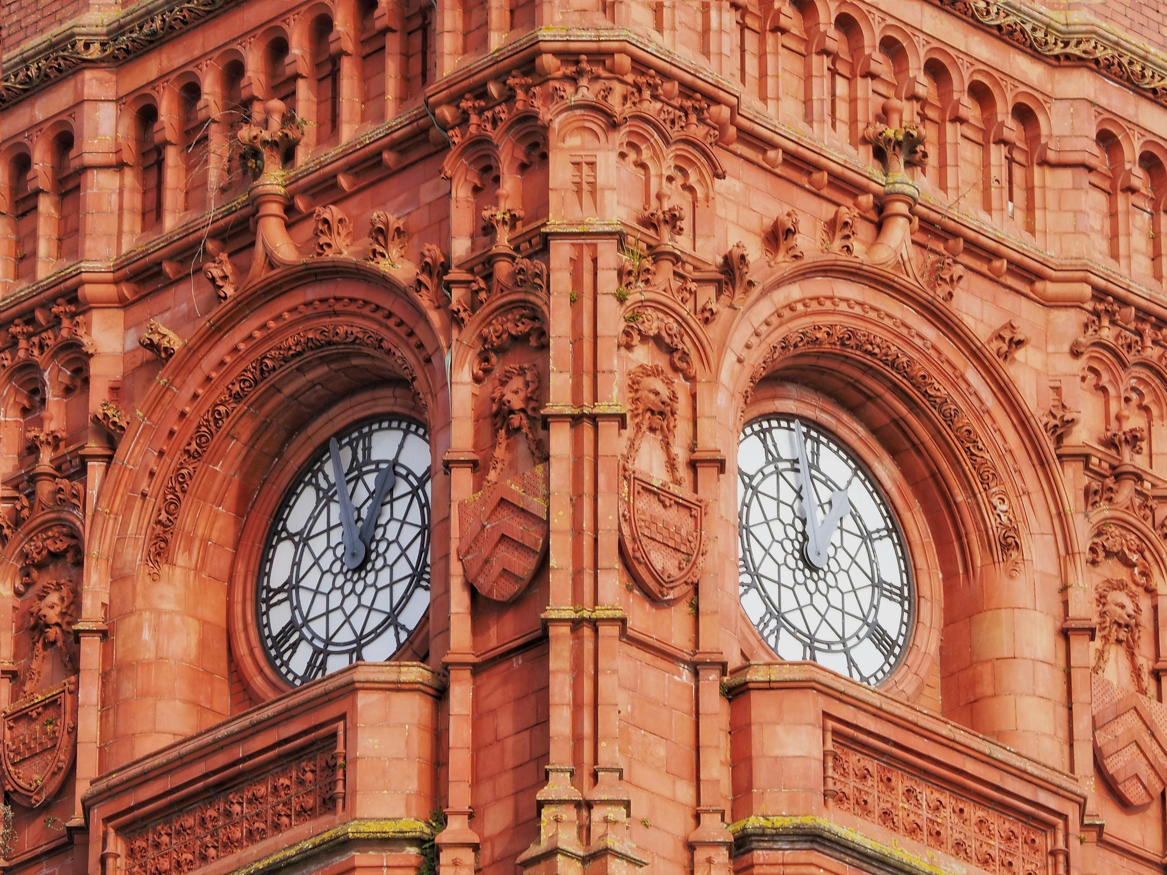 Ornate red sandstone building with two clock faces