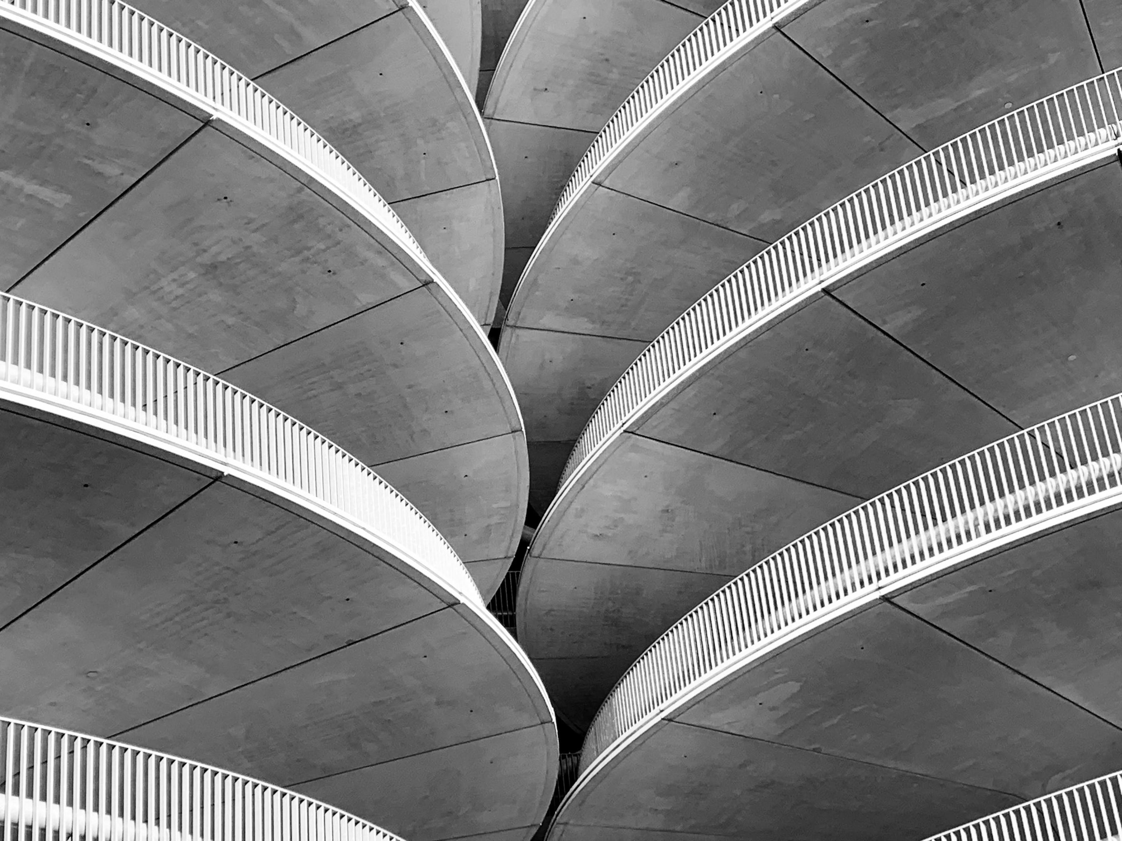 Gray concrete spiral stairs photographed in black and white