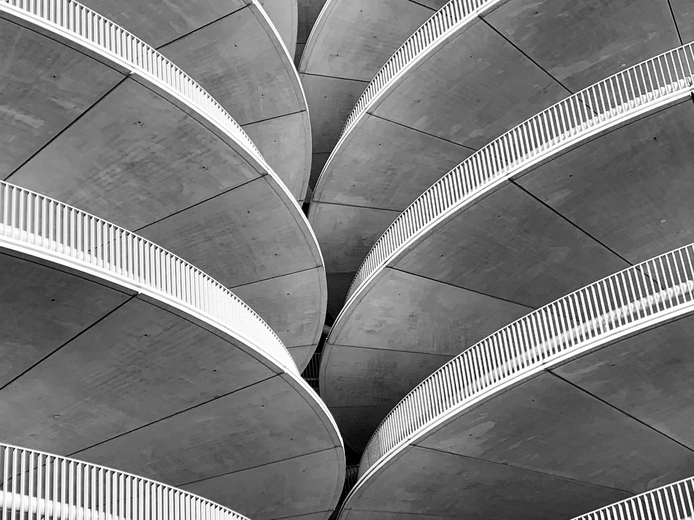 Gray concrete spiral stairs photographed in black and white