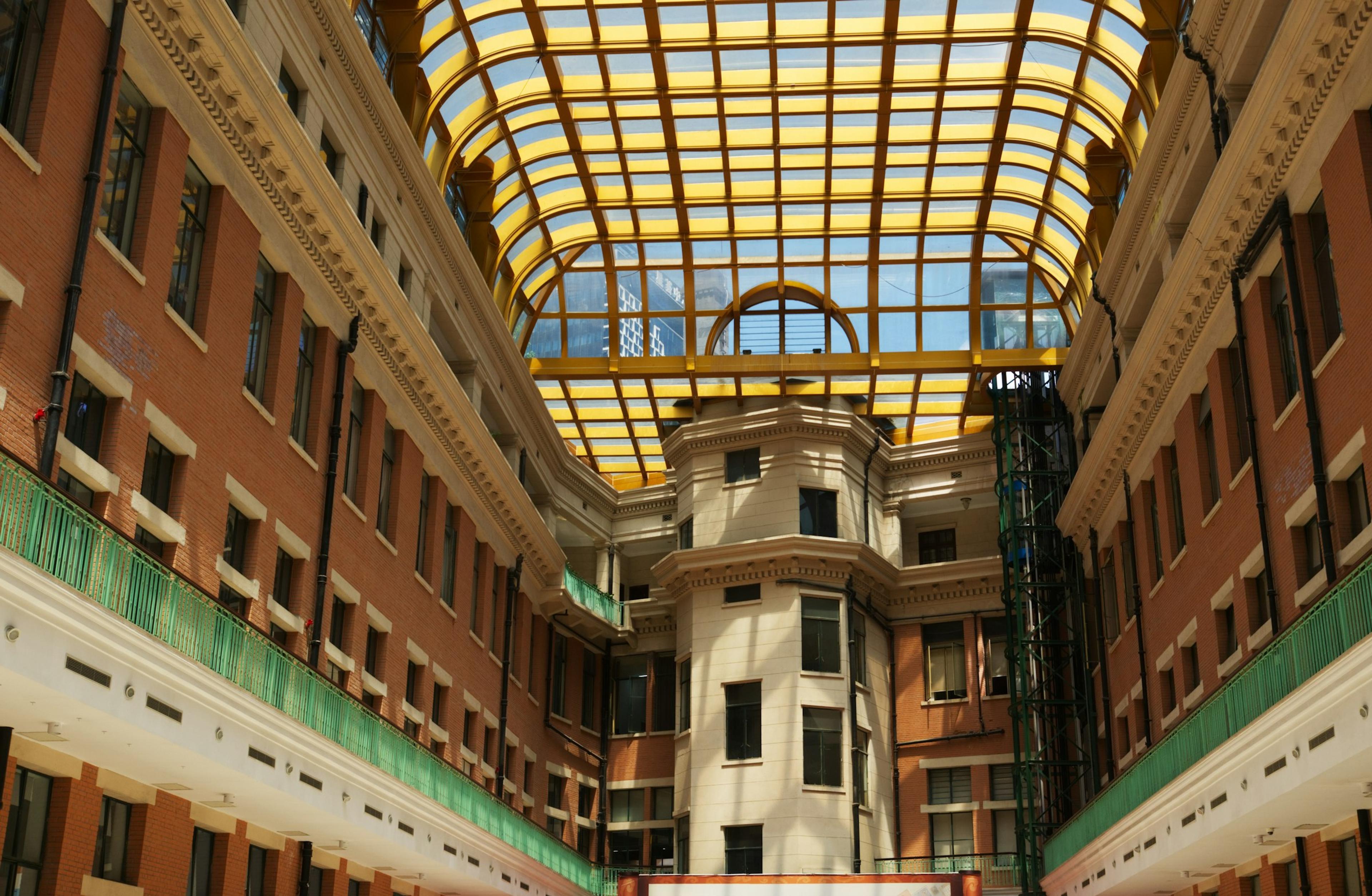 An interior courtyard with a glass roof and stacked balconies