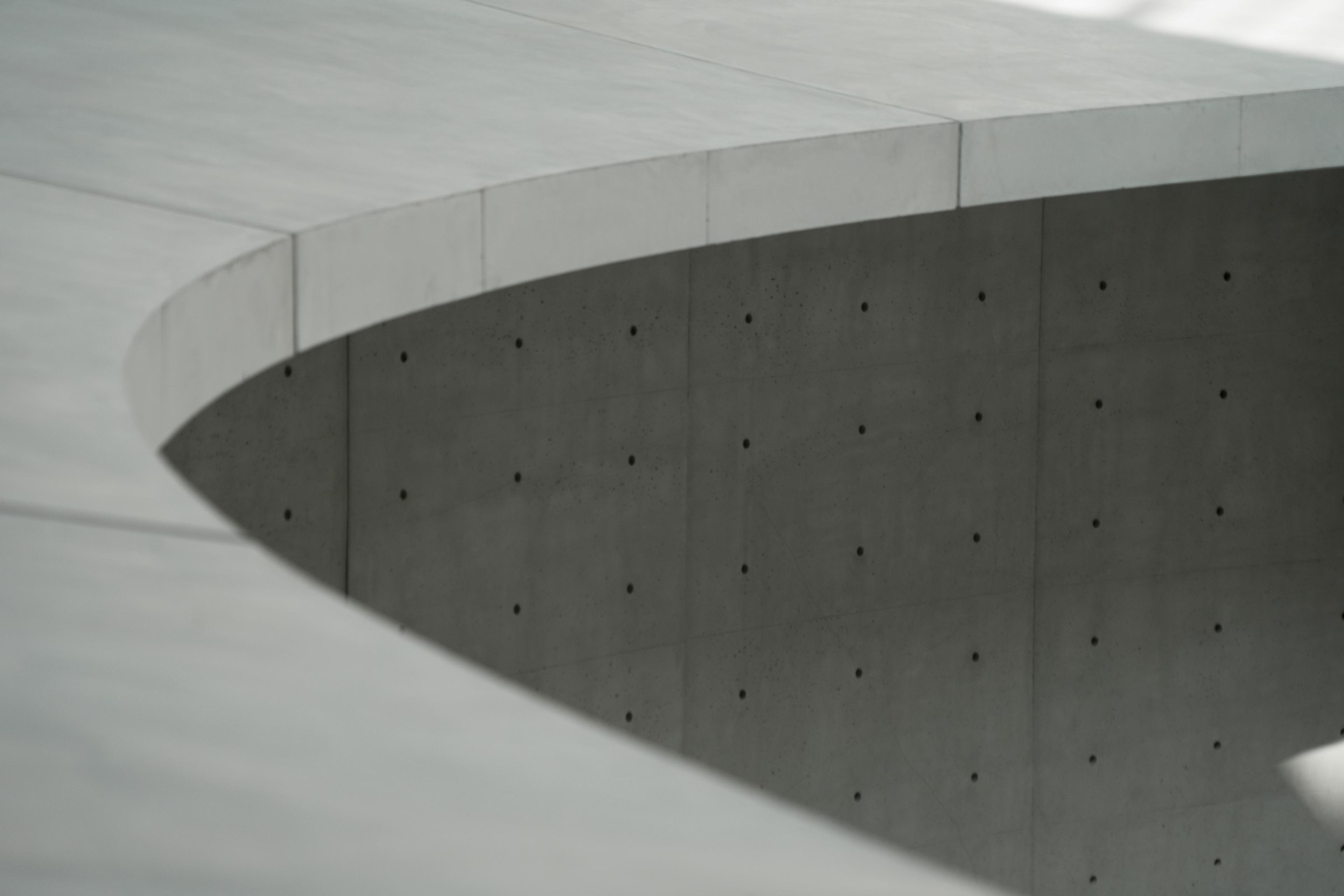 Gray concrete building under a white sky during daytime