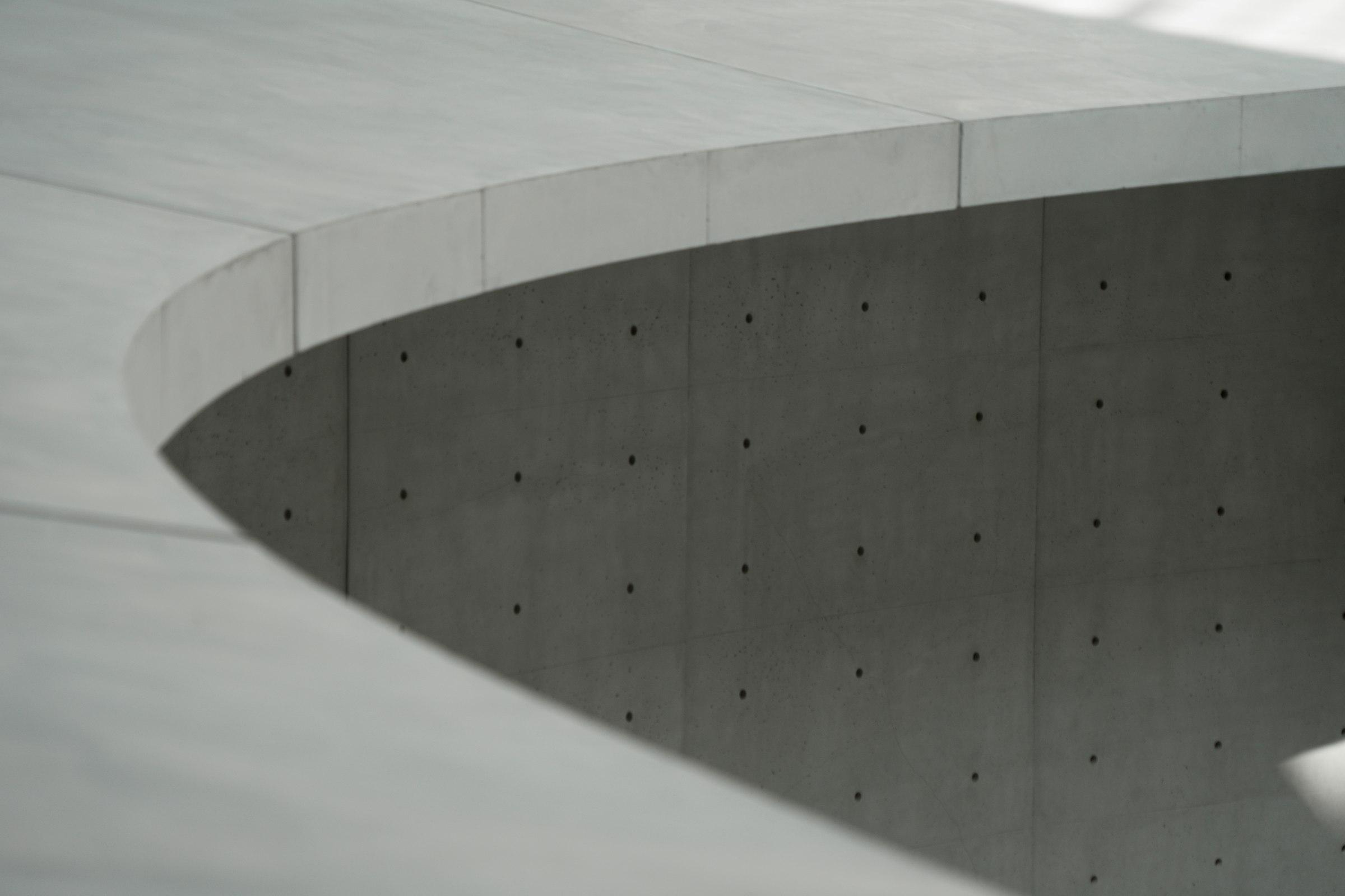 Gray concrete building under a white sky during daytime
