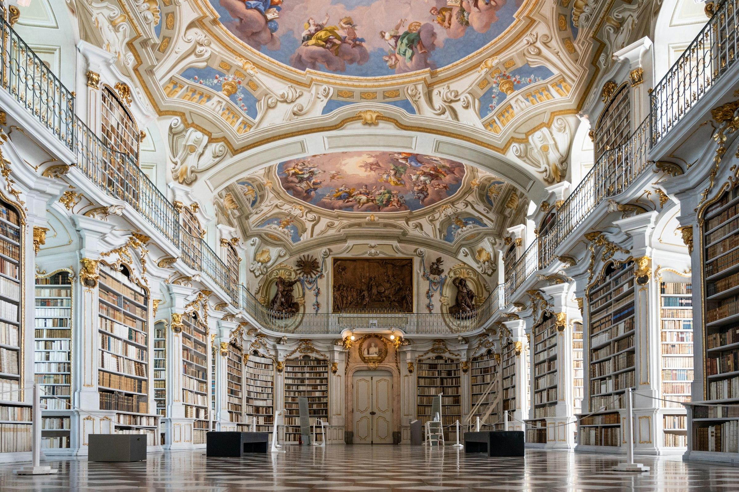 A tall reading room with bookshelves to the ceiling