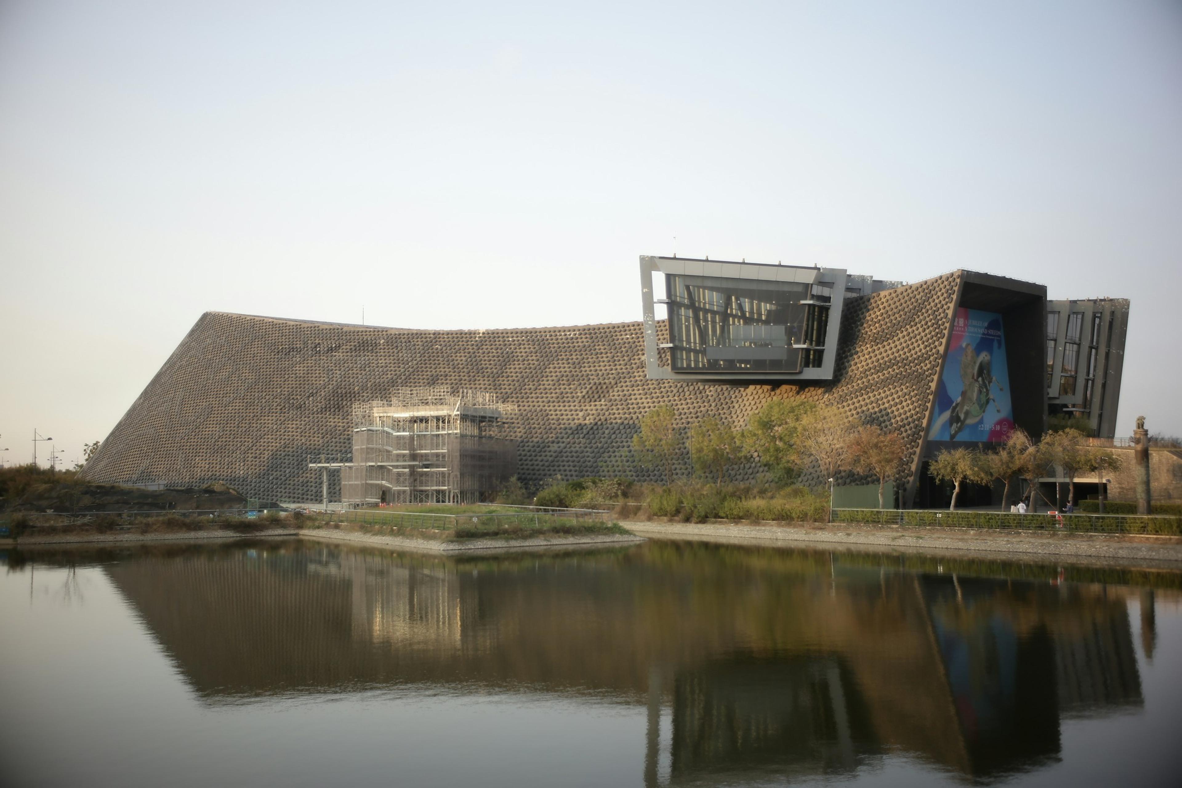 Modern building with an unusual profile reflected in water