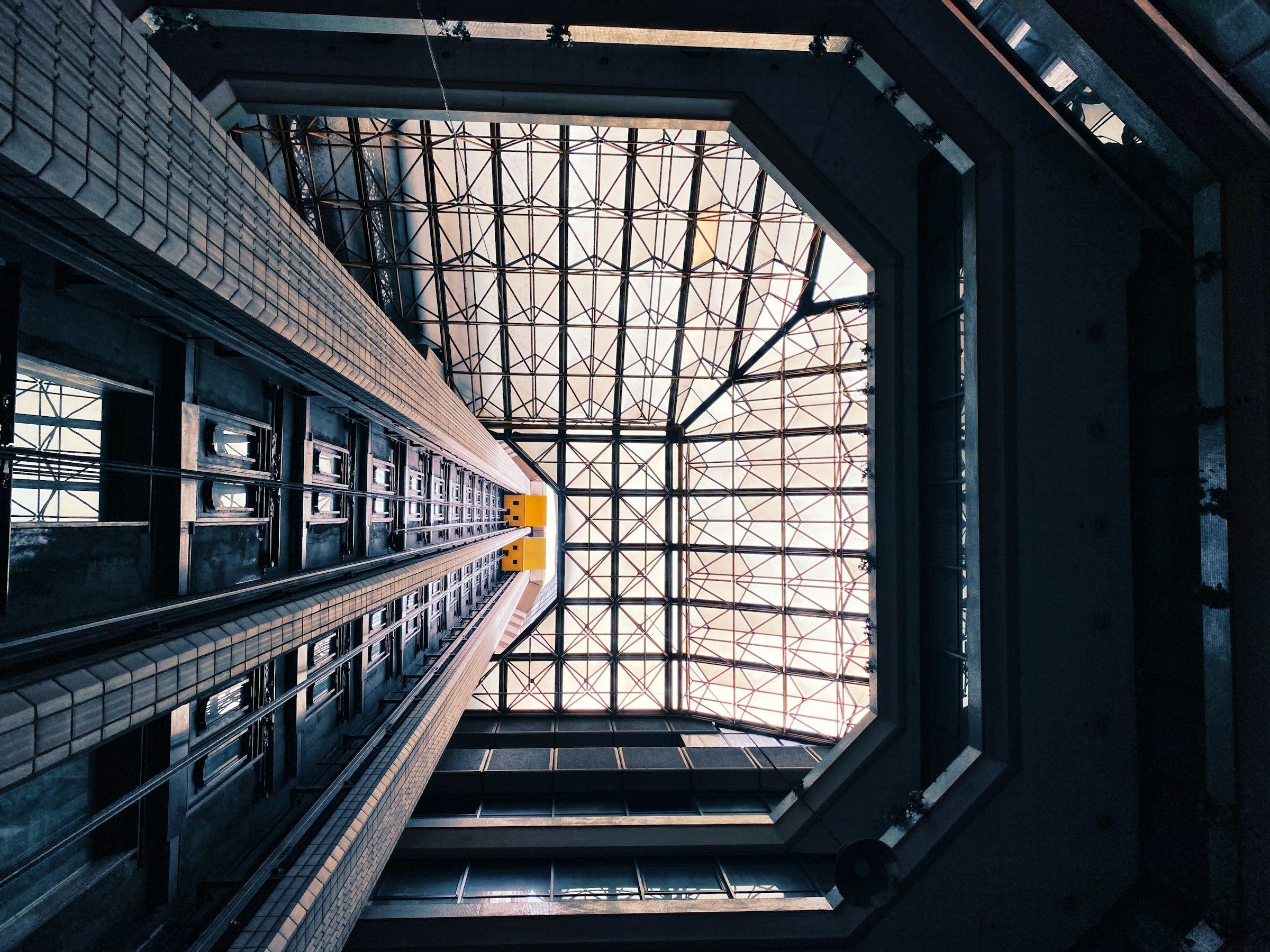 A dark glass-walled building seen from below
