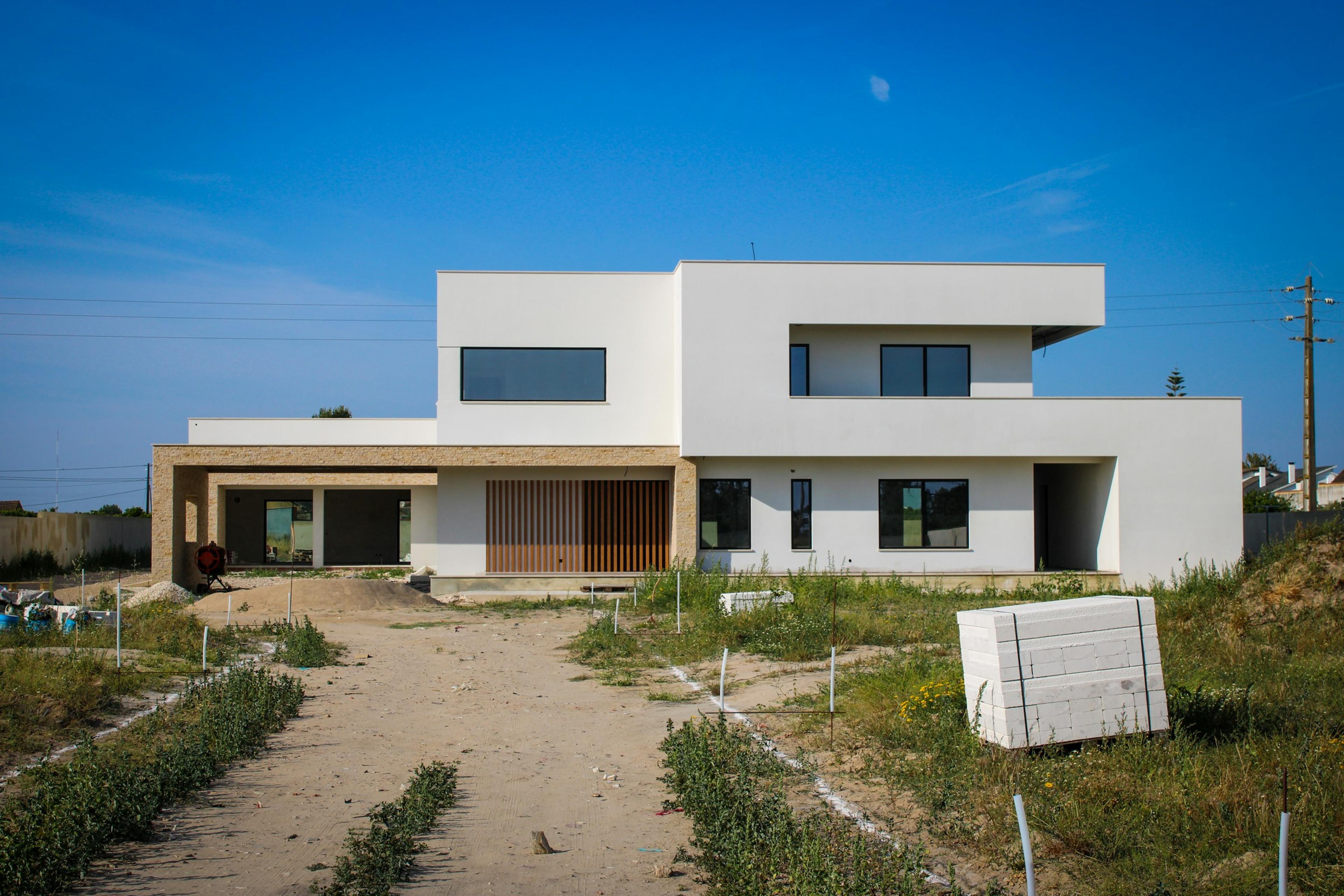 A white house sitting above an unmade road