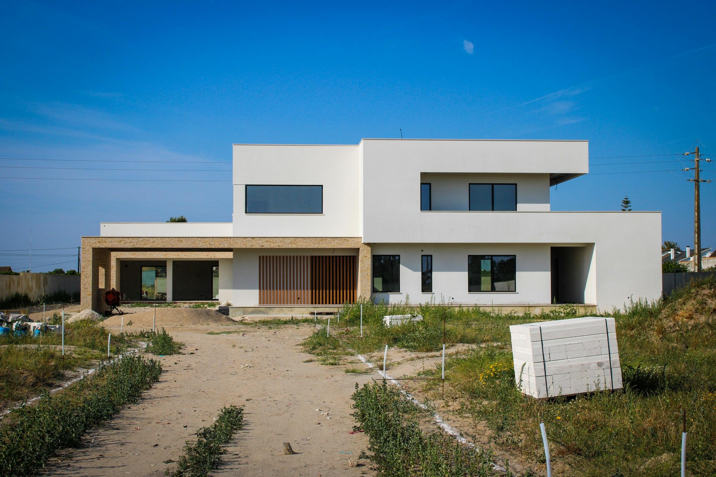 A white house sitting above an unmade road