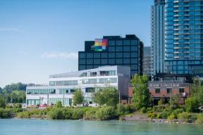 A photograph of RiverWalk in East Village from the north side of the Bow River.