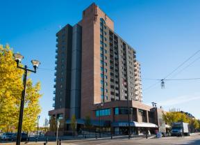 A photograph of the outside of the East Village Place building, a midrise apartment building