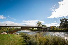 A photograph of the Elbow River Traverse bridge, a simple, elegant pedestrian bridge that spans the Elbow River.