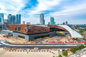 A photography of the BMO Centre expansion under construction in June 2023 showing many lifts on site and the cladding nearing completion