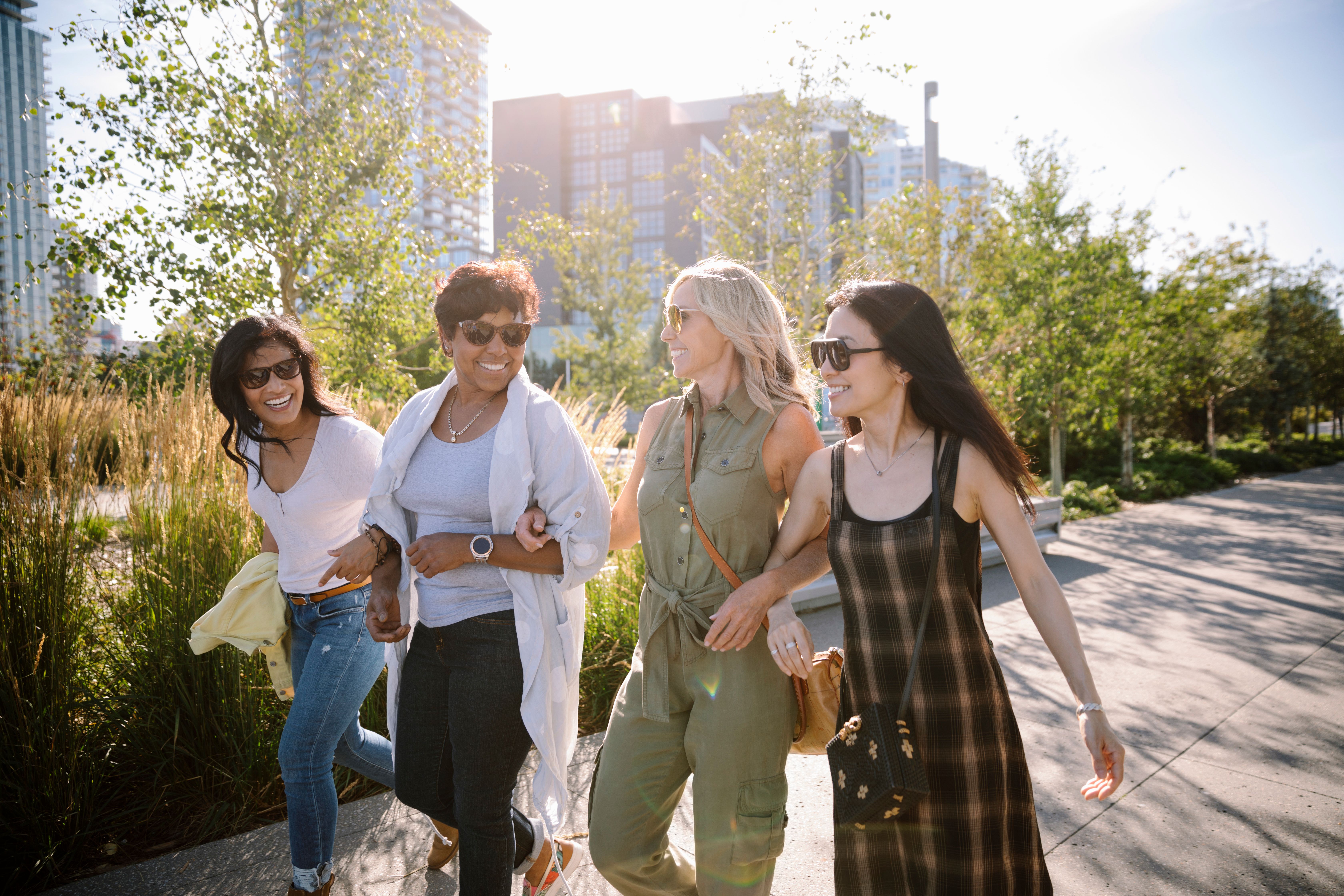 Four people walking along the RiverWalk in Calgary's East Village