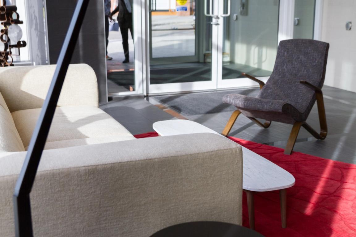 A photograph of a couch and chair in a condo building lobby.