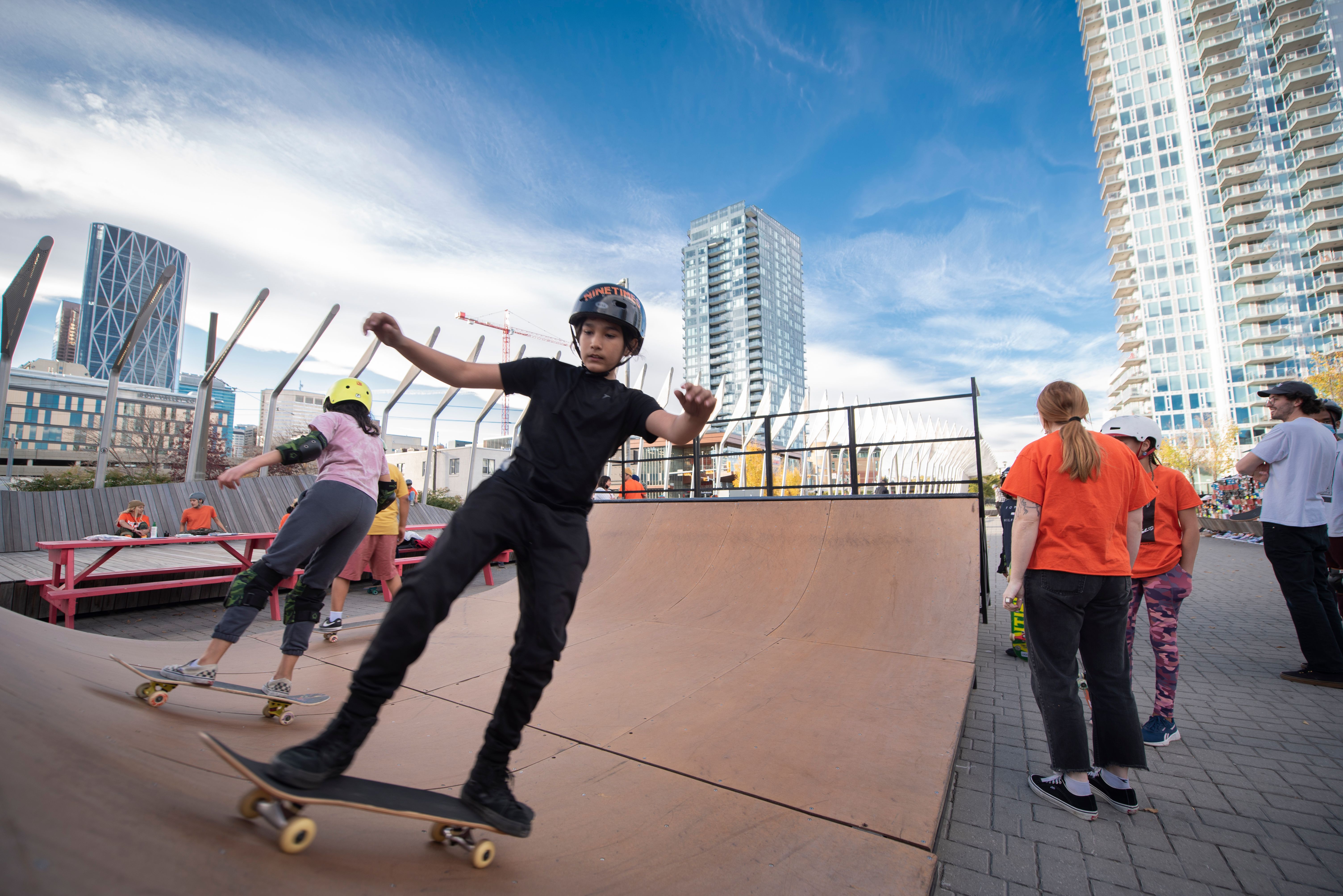 Kids skateboarding on a halfpipe in East Village Calgary