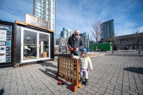 A photograph of an older man and a child playing connect four outside Hygge Hut