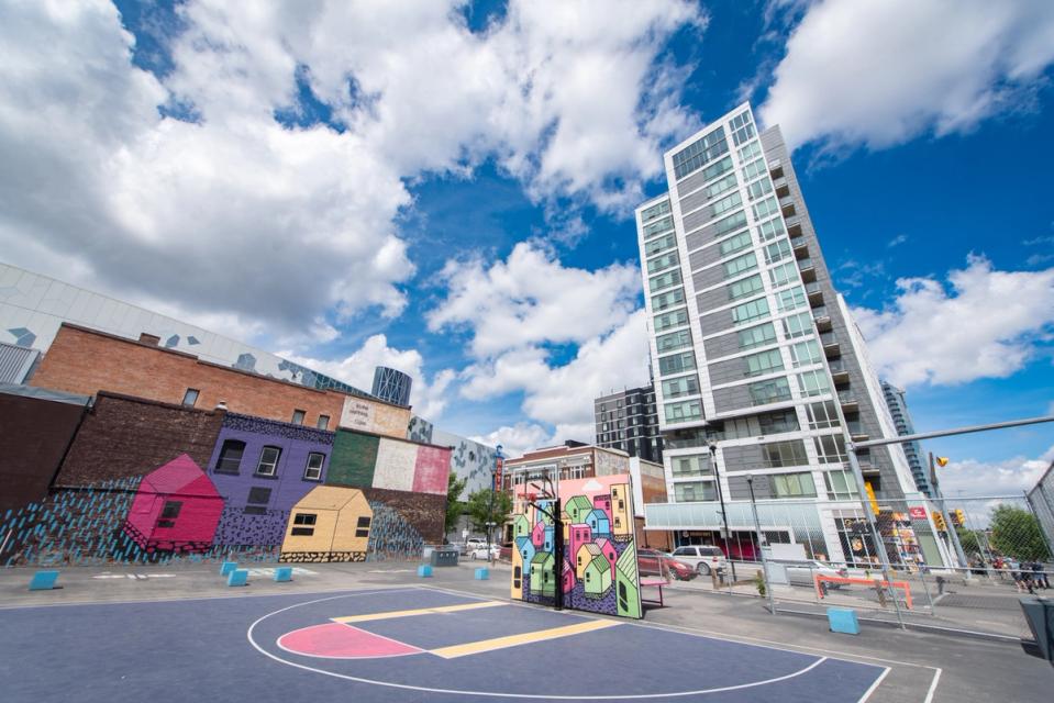 A photograph of The Bounce Games Park in East Village on a sunny day with vibrant murals by MAUD collective and the N3 residential tower in the background.