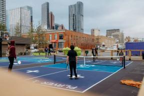 Photograph of four people playing pickleball.