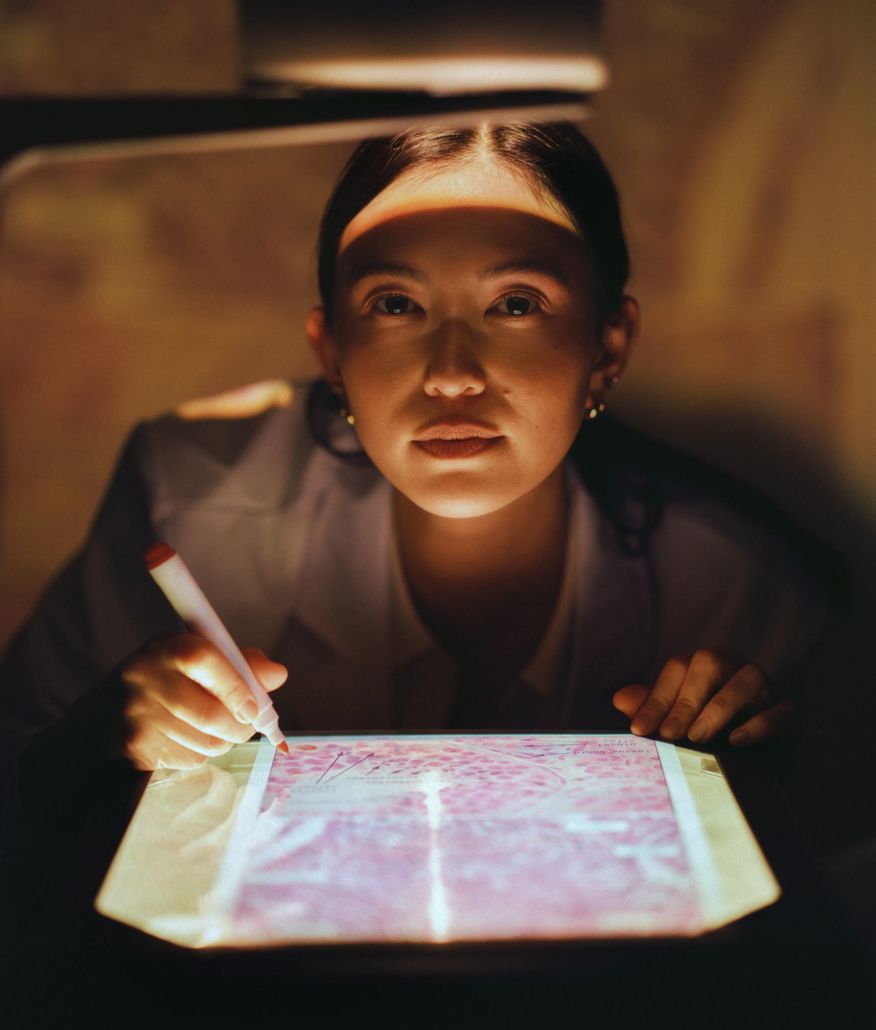 Woman highlighting notes in a book by low light