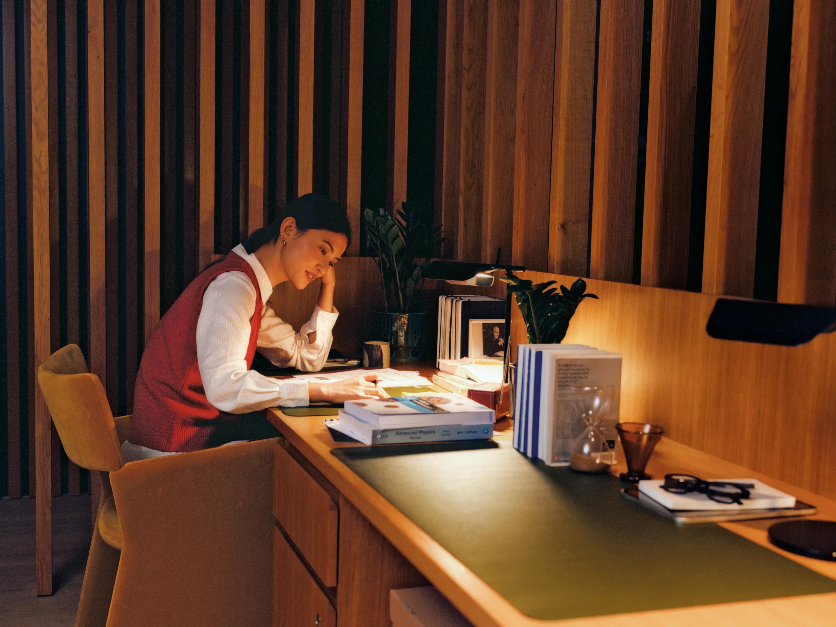 A resident working at a desk under a lamp