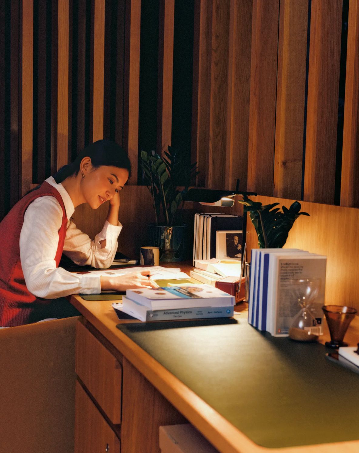 A resident working at a desk under a lamp