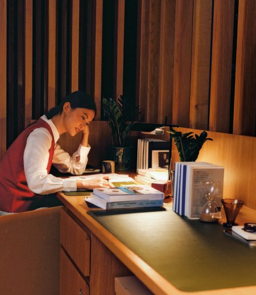 A resident working at a desk under a lamp