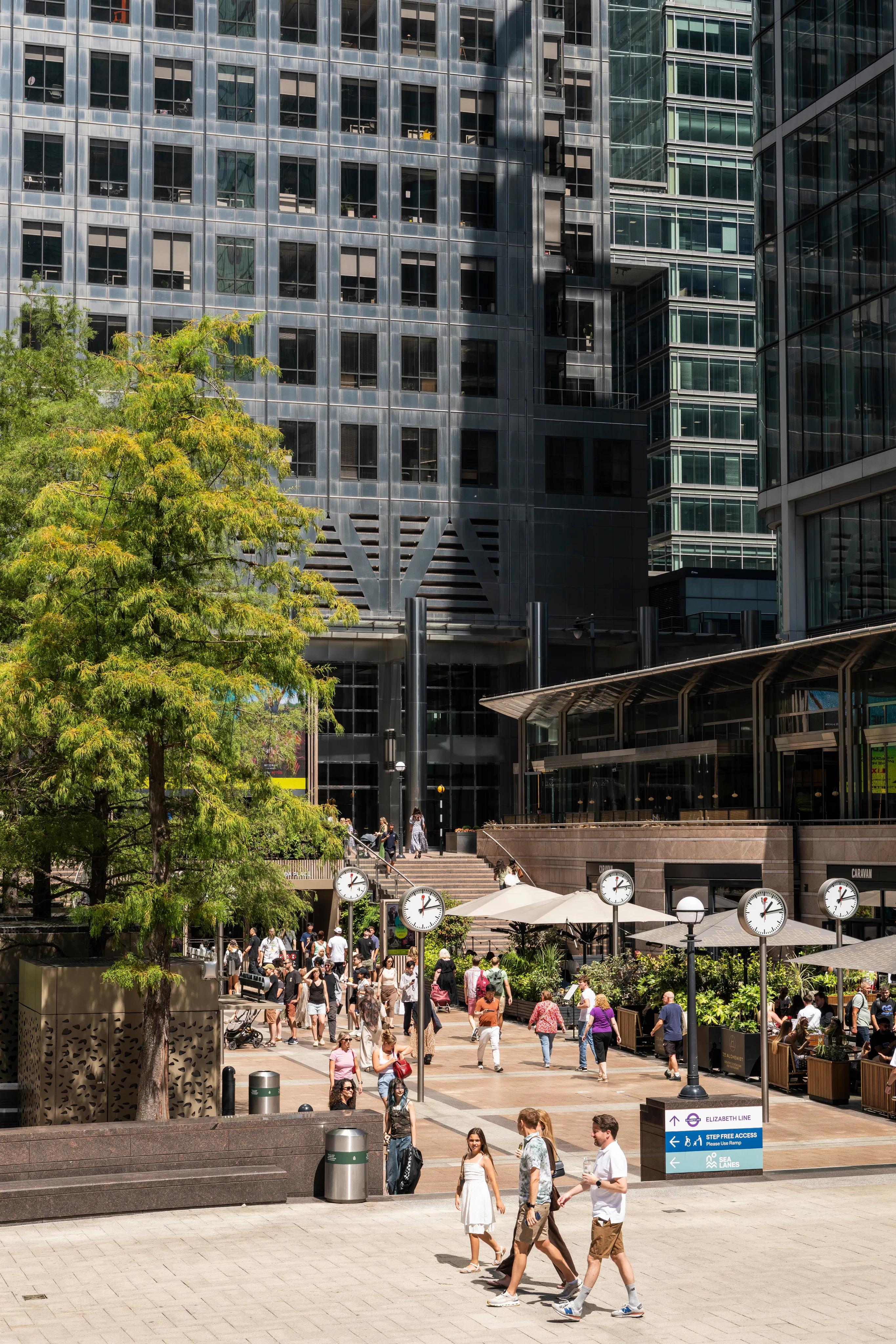 Office workers crossing the clock plaza at Canary Wharf