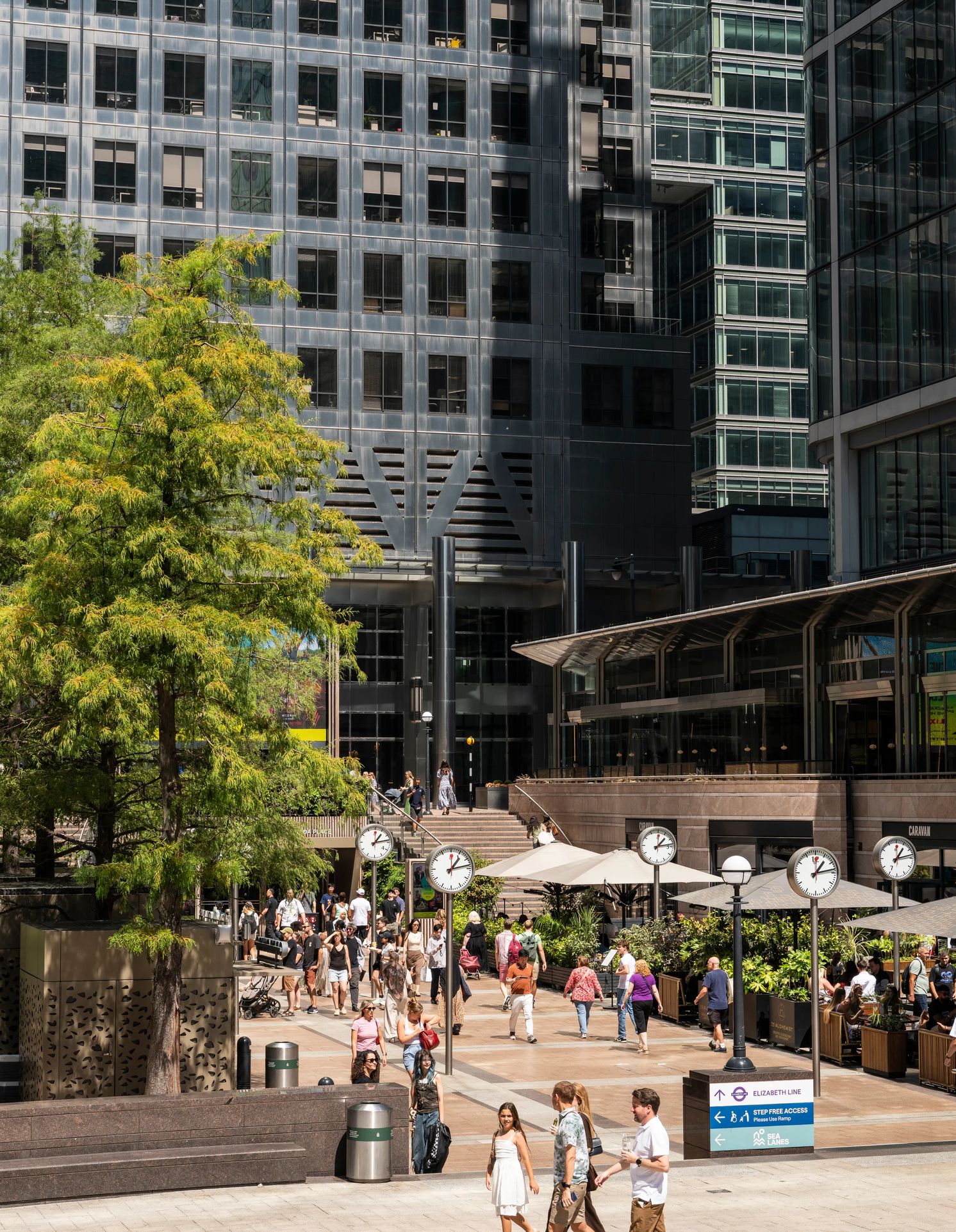 Office workers crossing the clock plaza at Canary Wharf