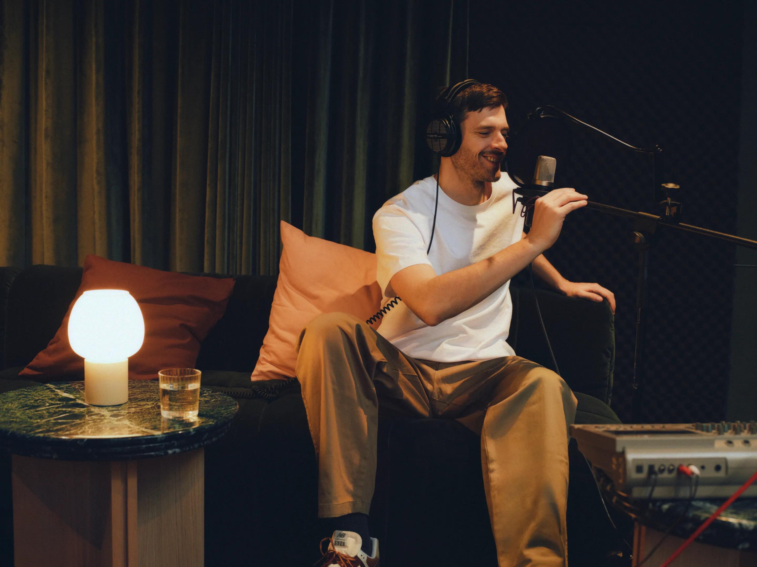 A resident recording a podcast at a standing microphone