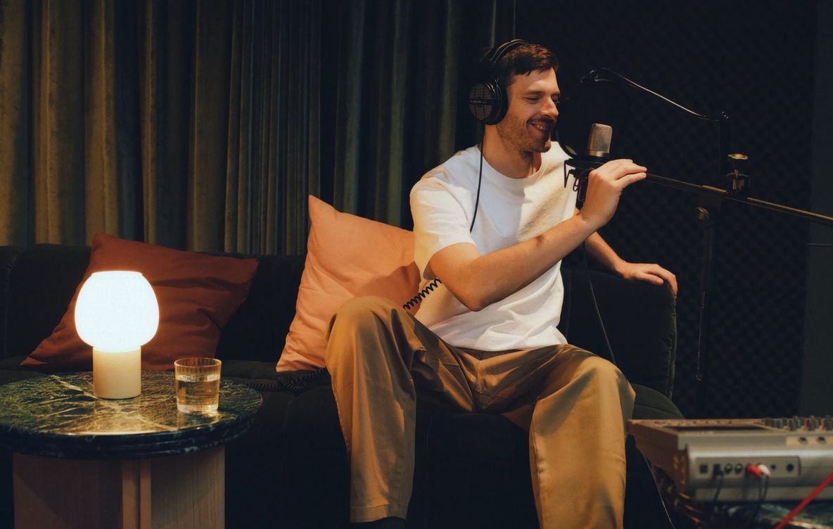 A resident recording a podcast at a standing microphone