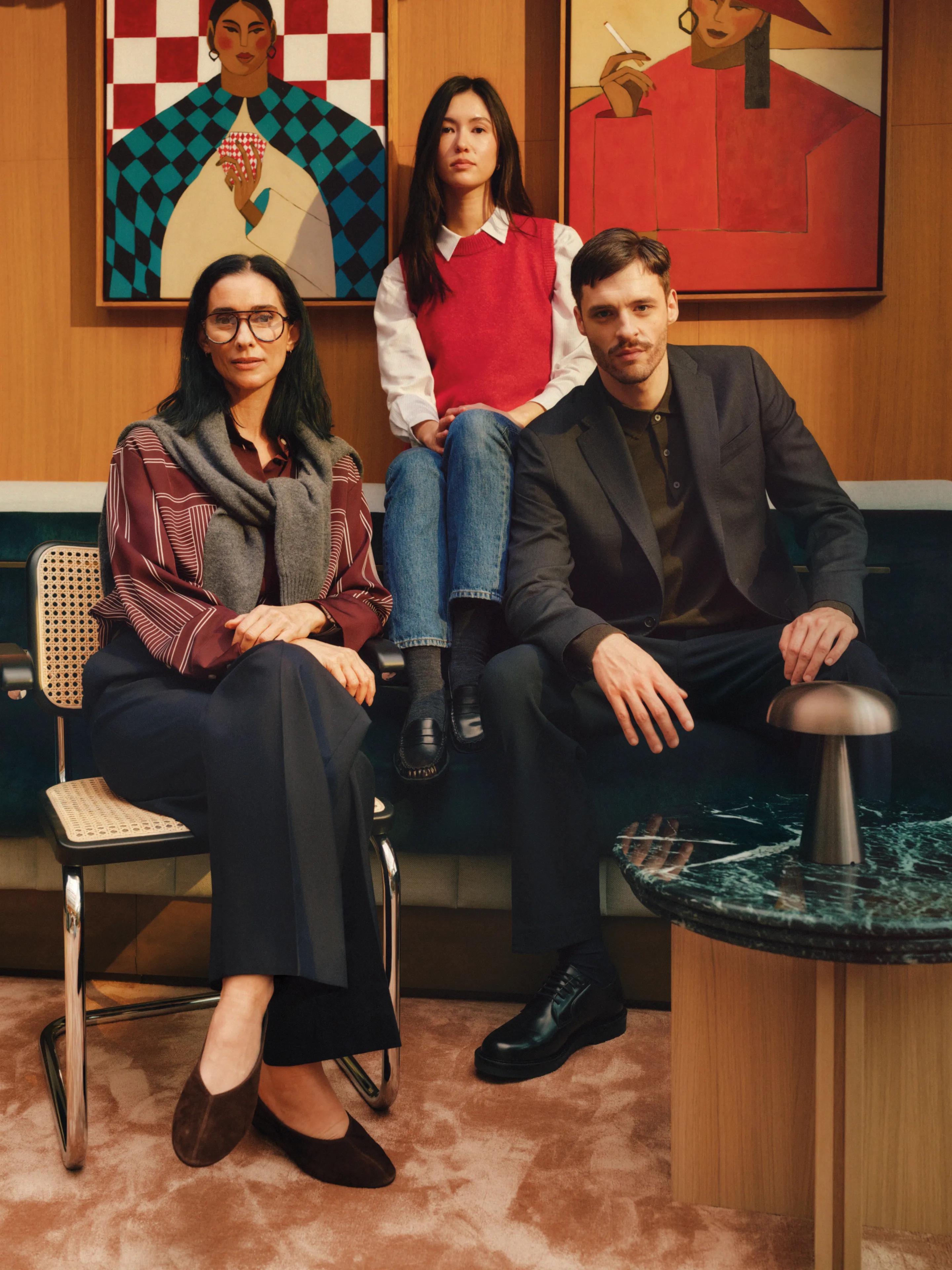 Three residents seated in a lounge below bold framed artwork